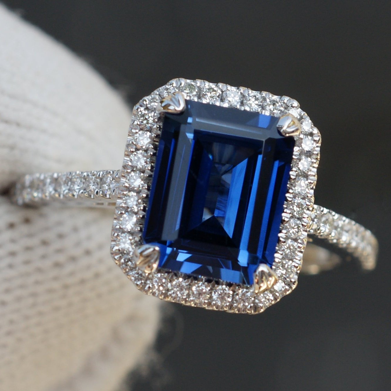 Emerald cut 9x7mm blue sapphire engagement ring with diamond halo and white gold