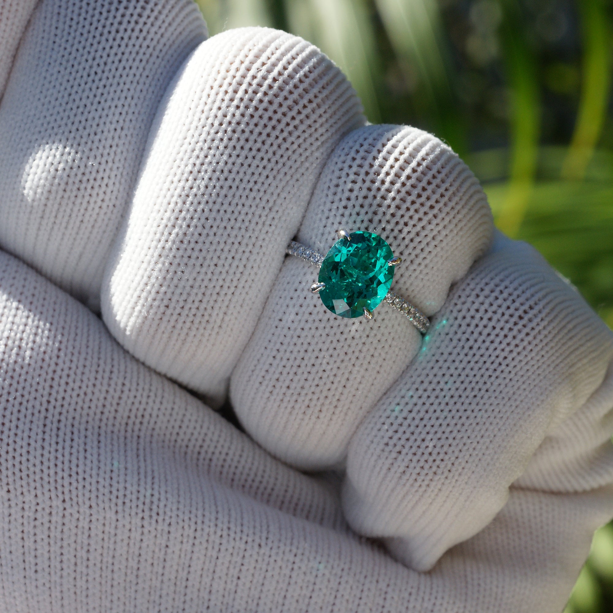 Oval cut lab-grown emerald and diamond solitaire engagement ring platinum