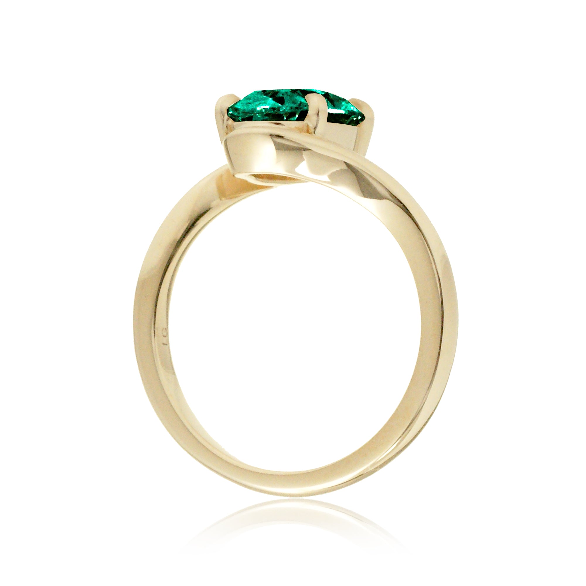 Elegant yellow gold bypass ring featuring an oval-cut emerald
