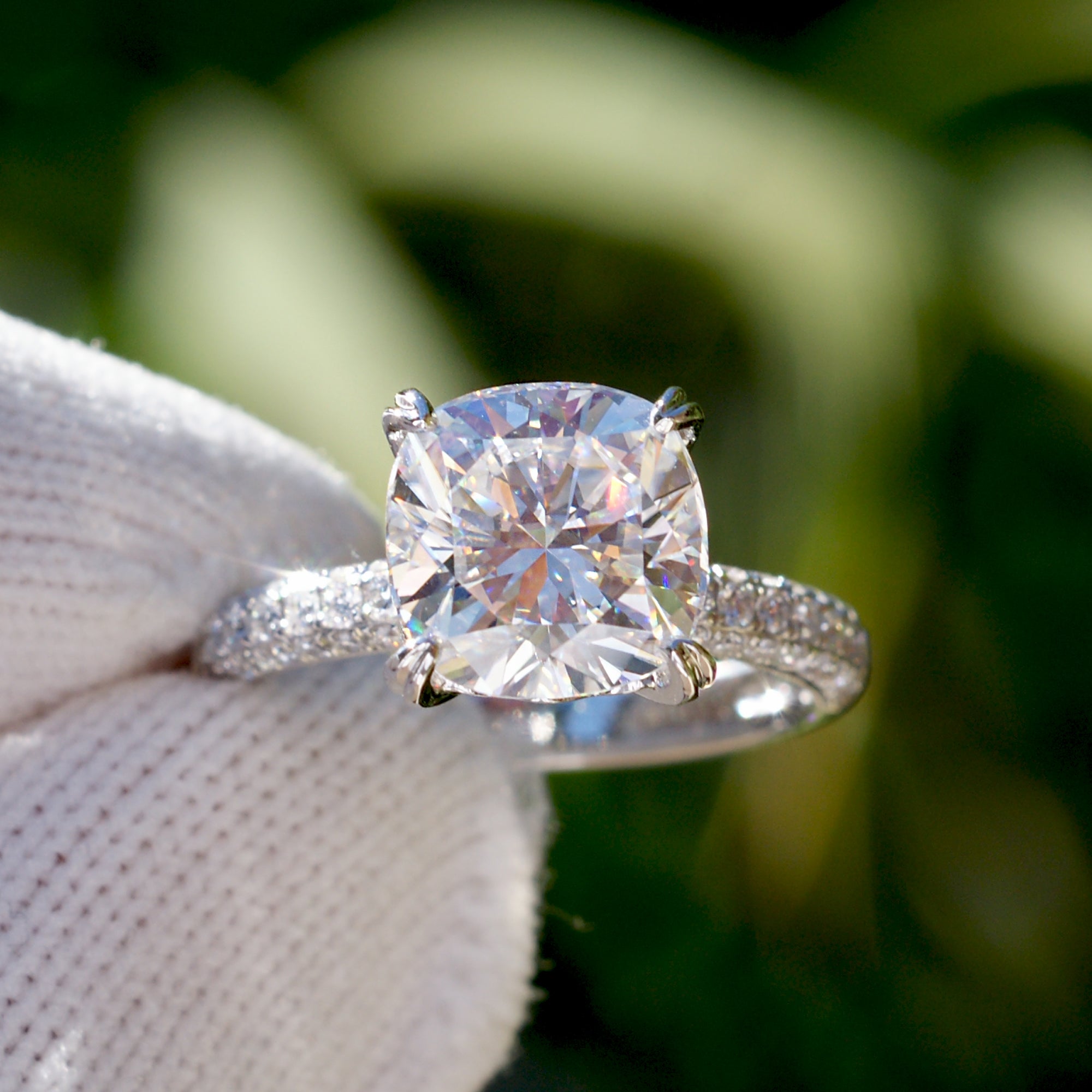 Cushion moissanite engagement ring with a pavé diamond band in white gold