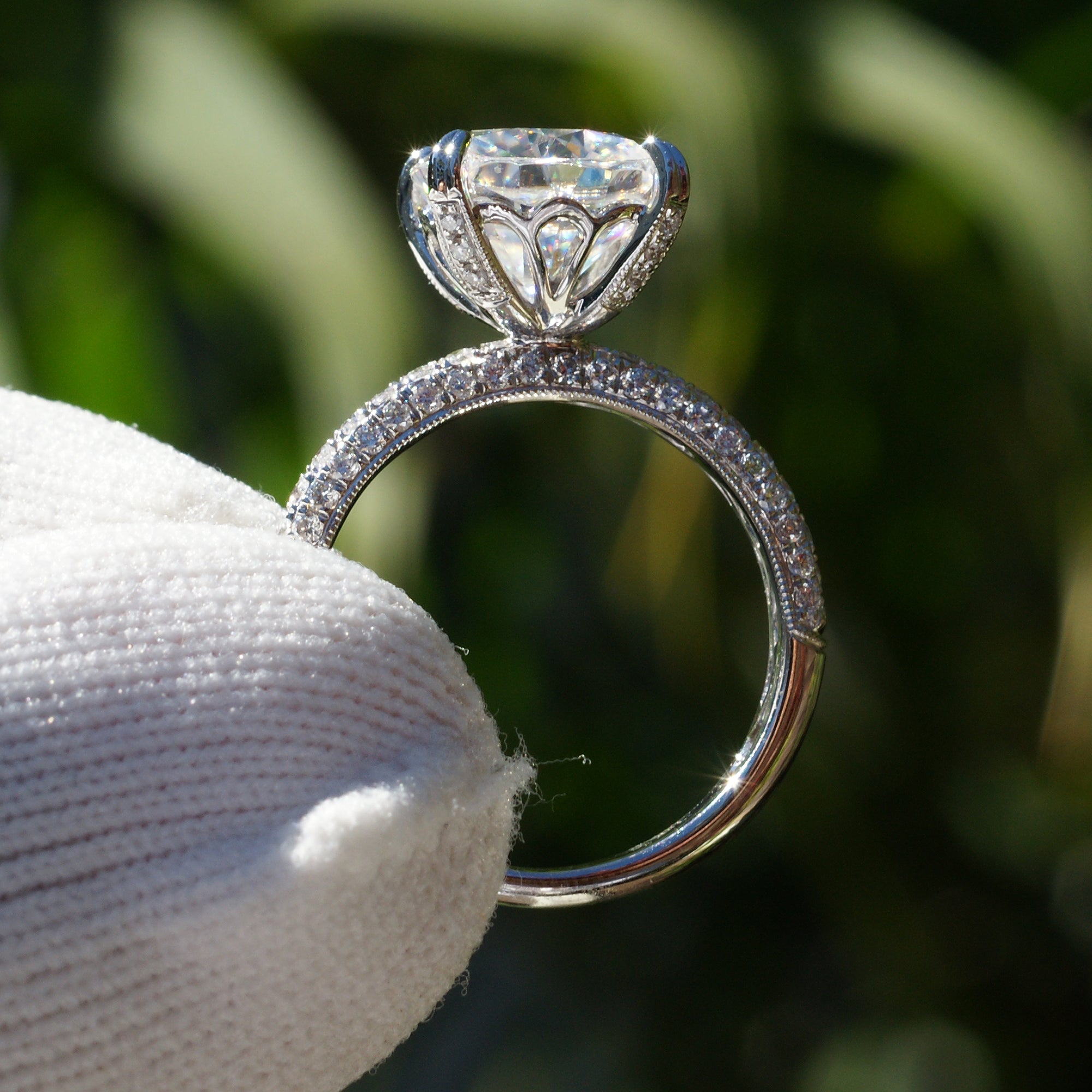 Cushion moissanite engagement ring with a pavé diamond band in white gold