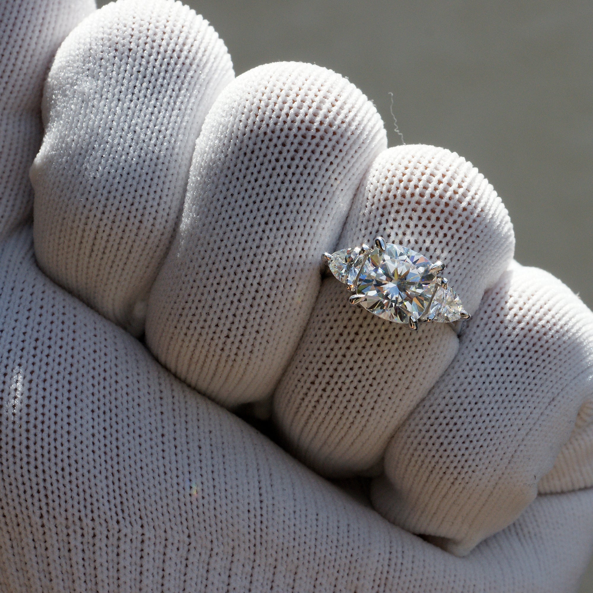 Cushion moissanite three stone ring with trillion on each side in white gold