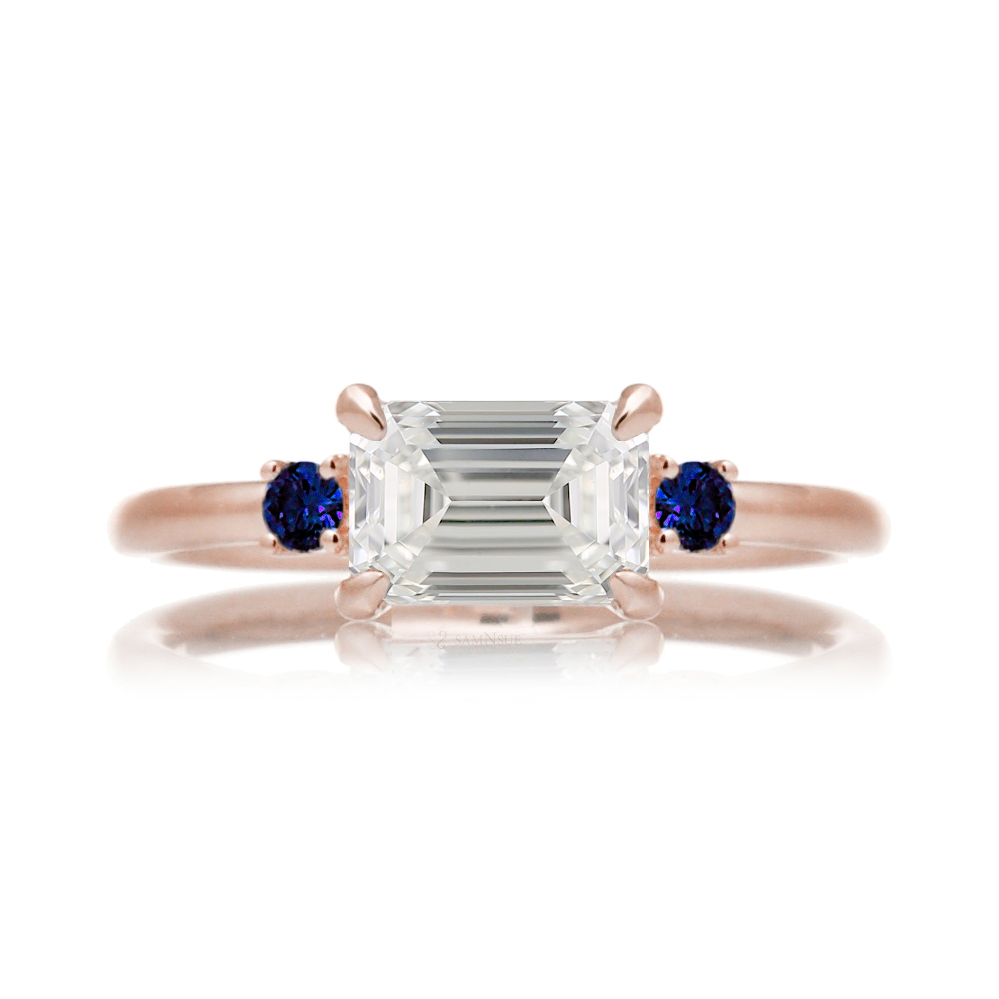 east-west emerald cut diamond three stone ring the Lena with side blue sapphires rose gold