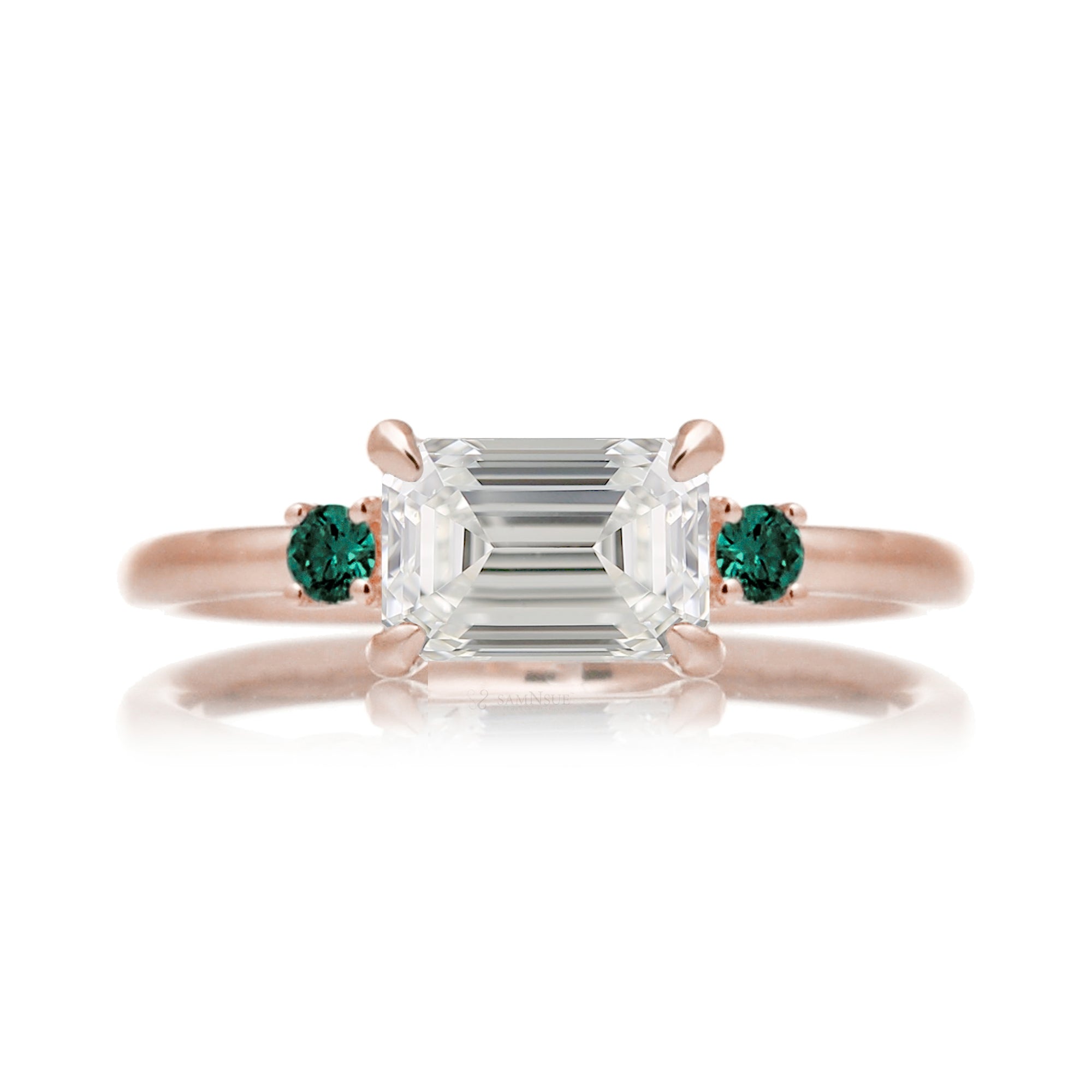 east-west emerald cut diamond three stone ring the Lena with side green emeralds rose gold