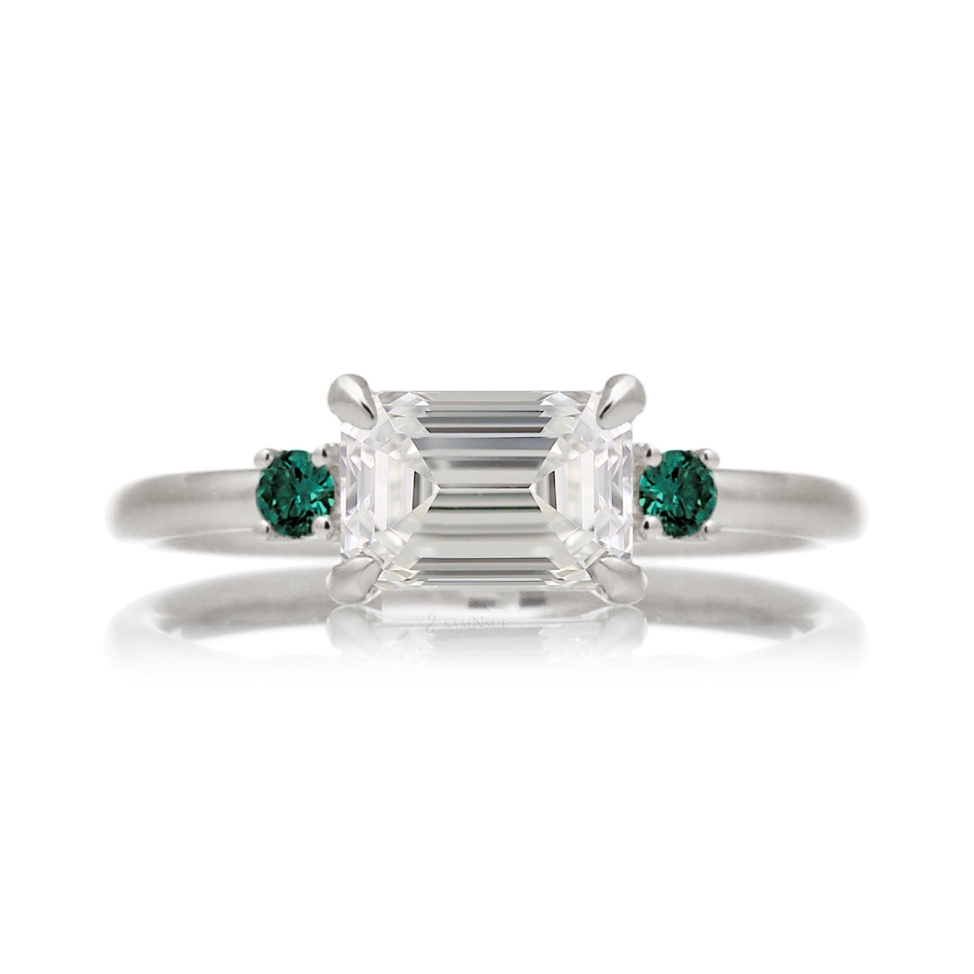 east-west emerald cut diamond three stone ring the Lena with side green emeralds white gold
