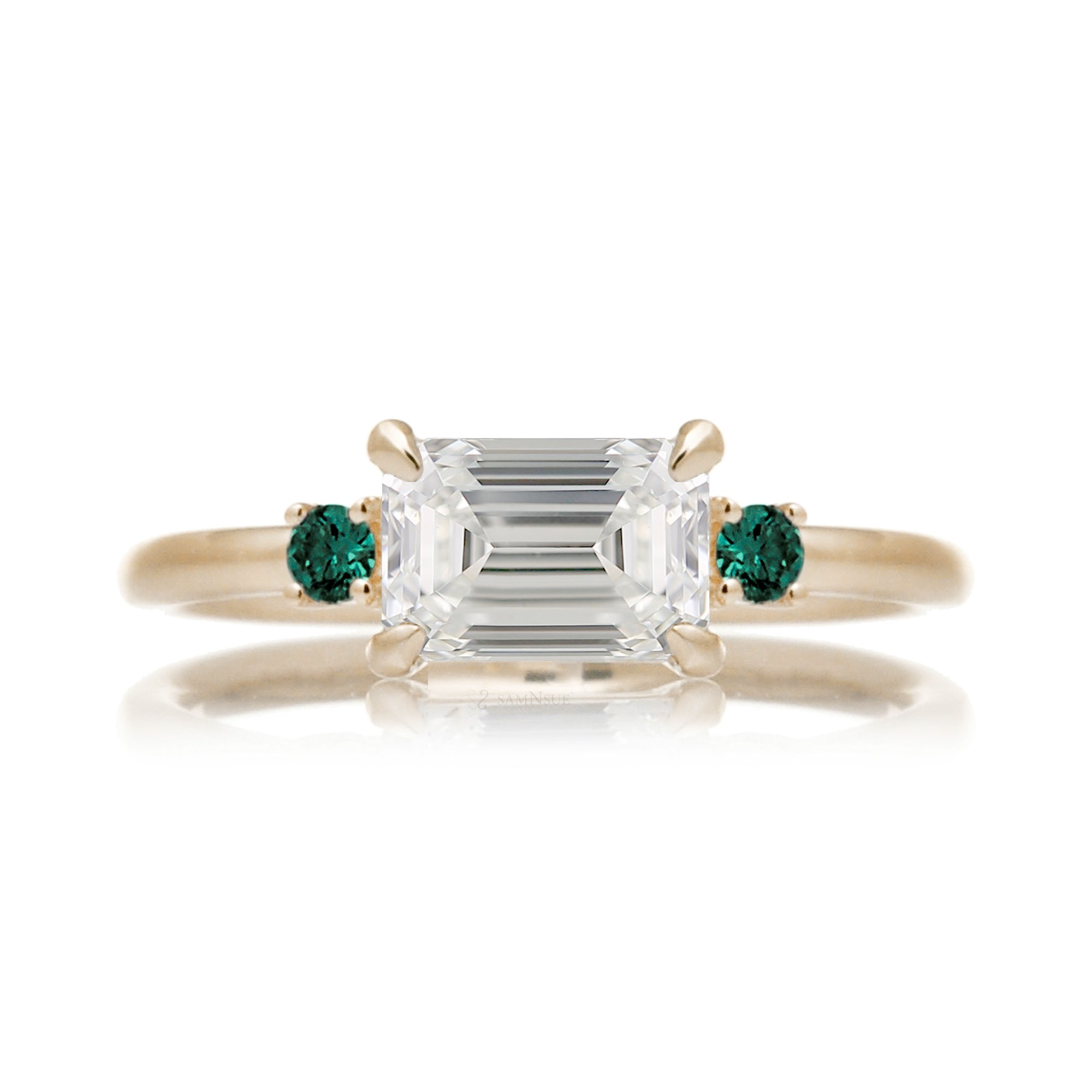 east-west emerald cut diamond three stone ring the Lena with side green emeralds yellow gold
