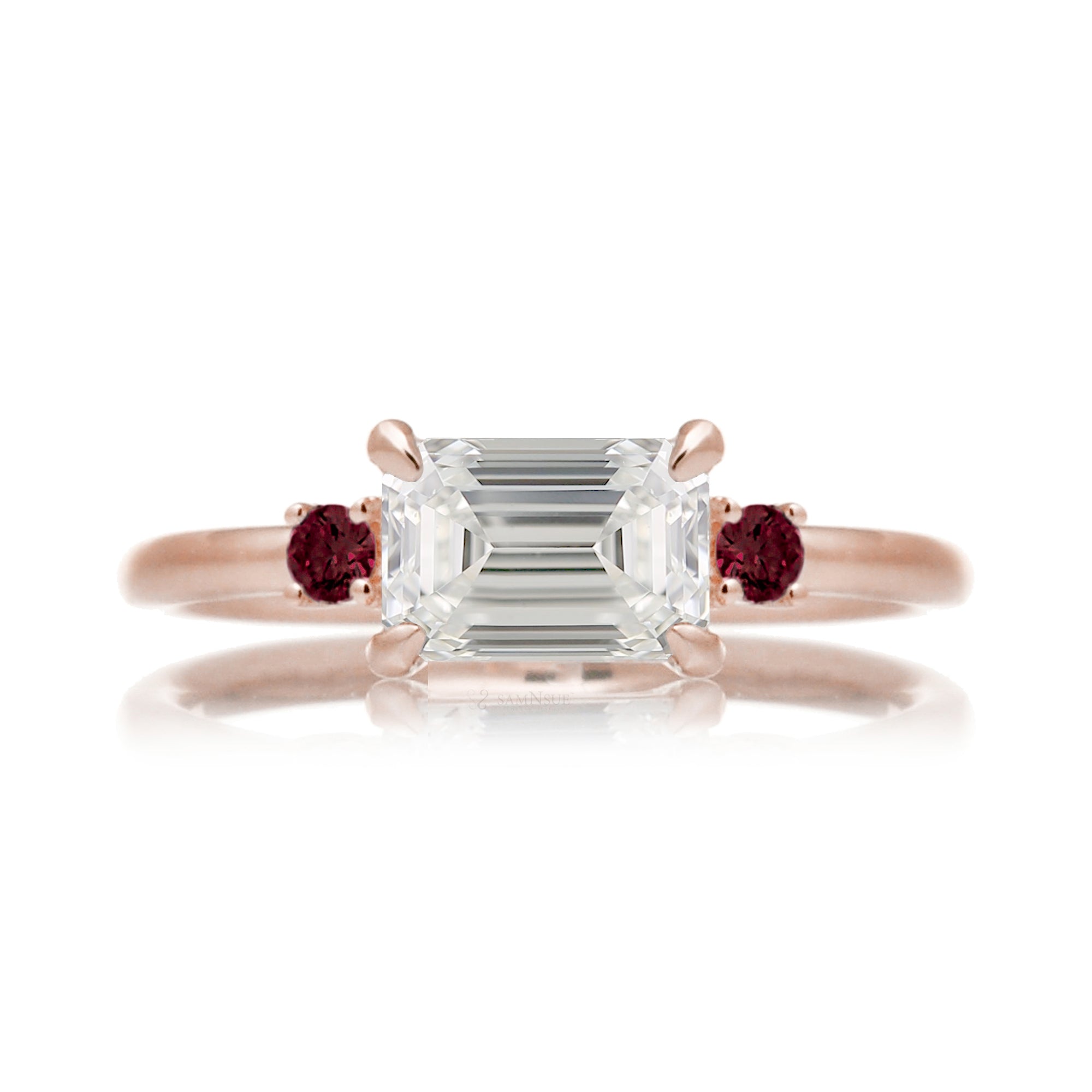 east-west emerald cut diamond three stone ring the Lena with side red rubies rose gold