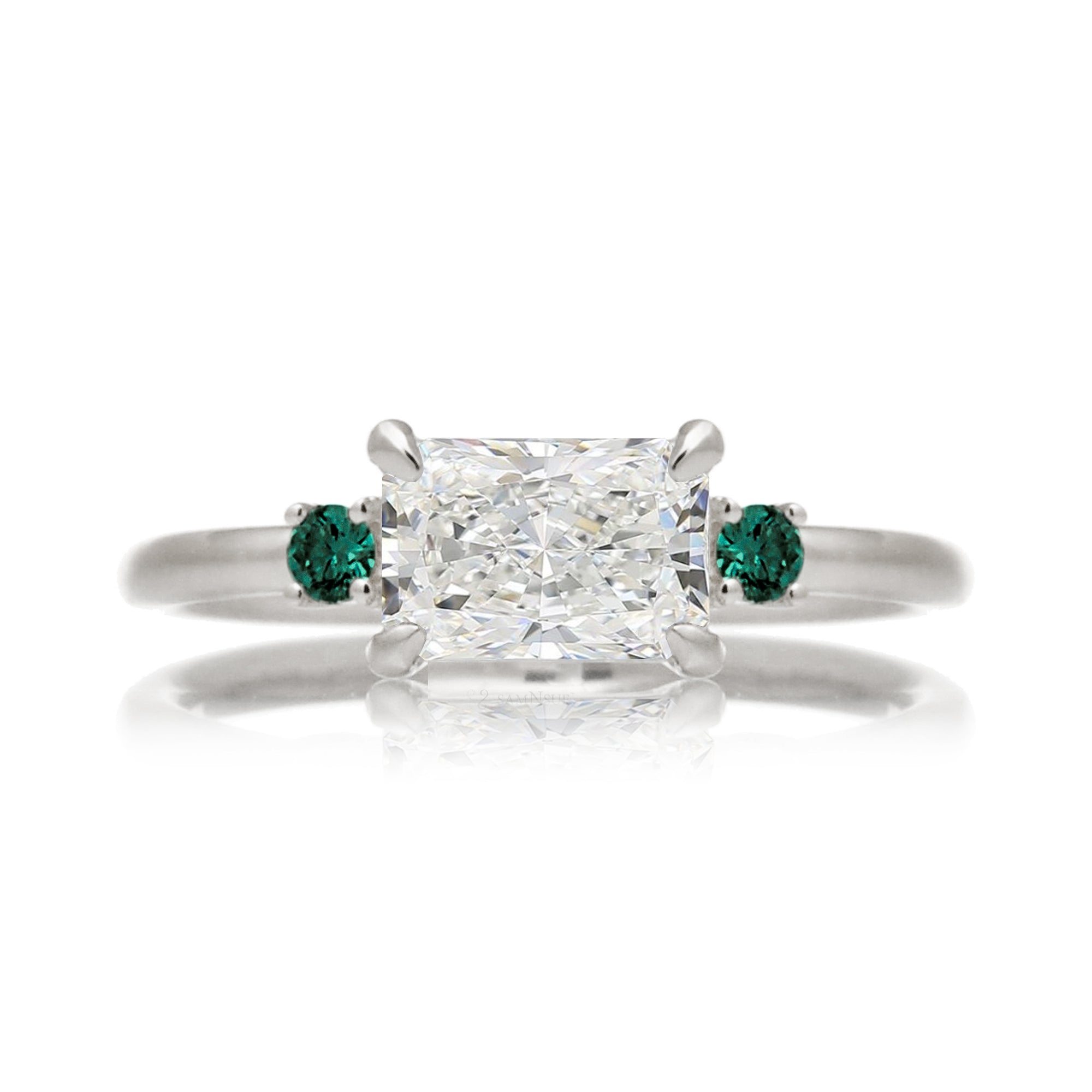 east-west radiant cut lab-grown diamond threestone ring with green emerald white gold