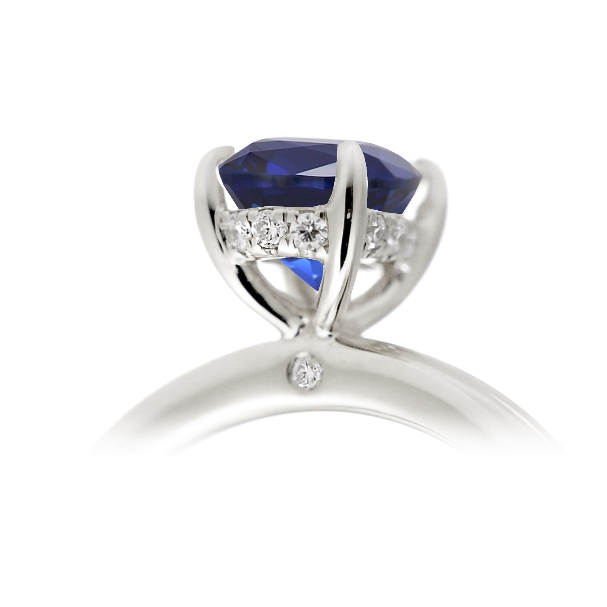 Oval cut blue sapphire engagement ring with a diamond hidden halo and solid band white gold