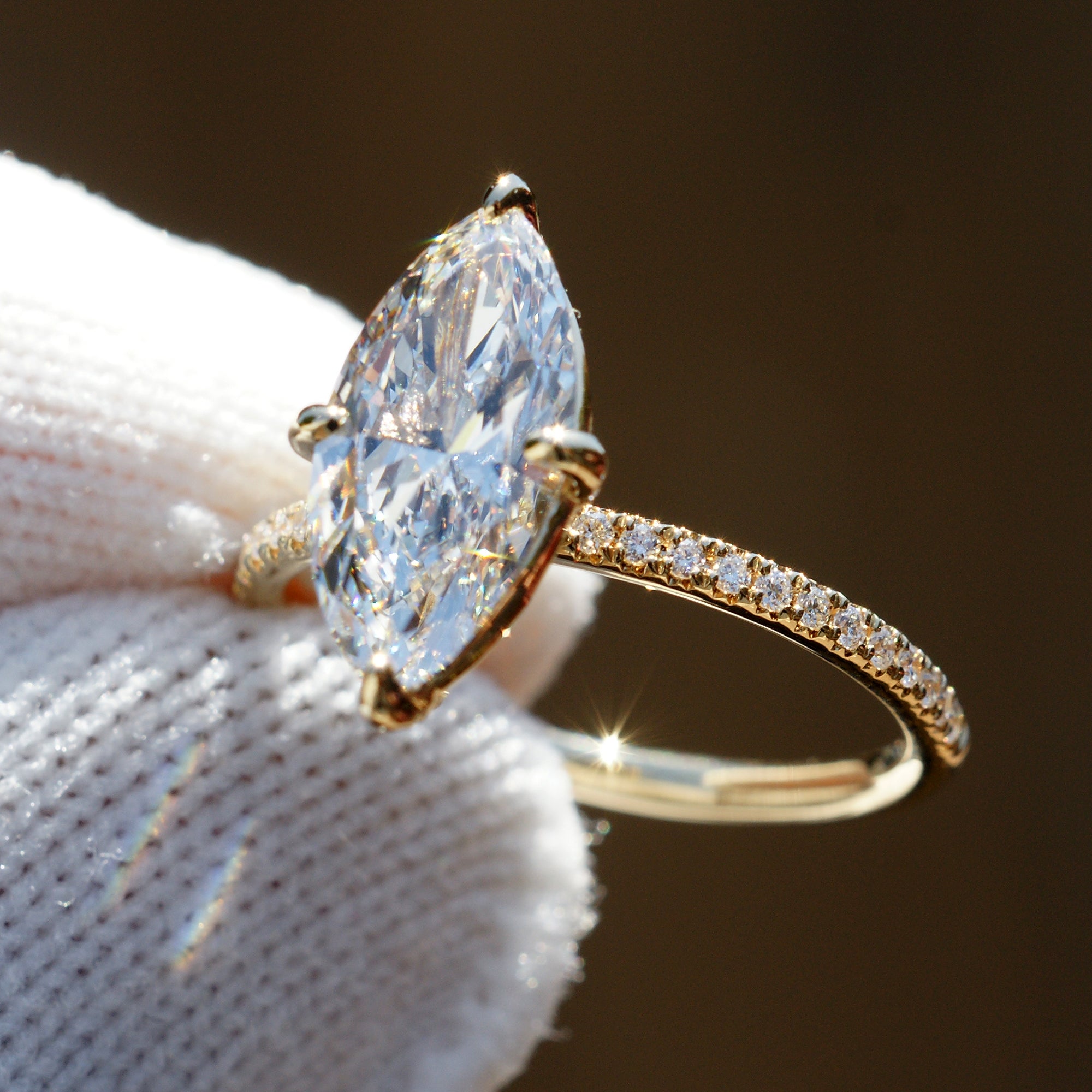 Marquise diamond engagement ring in yellow gold half diamond band