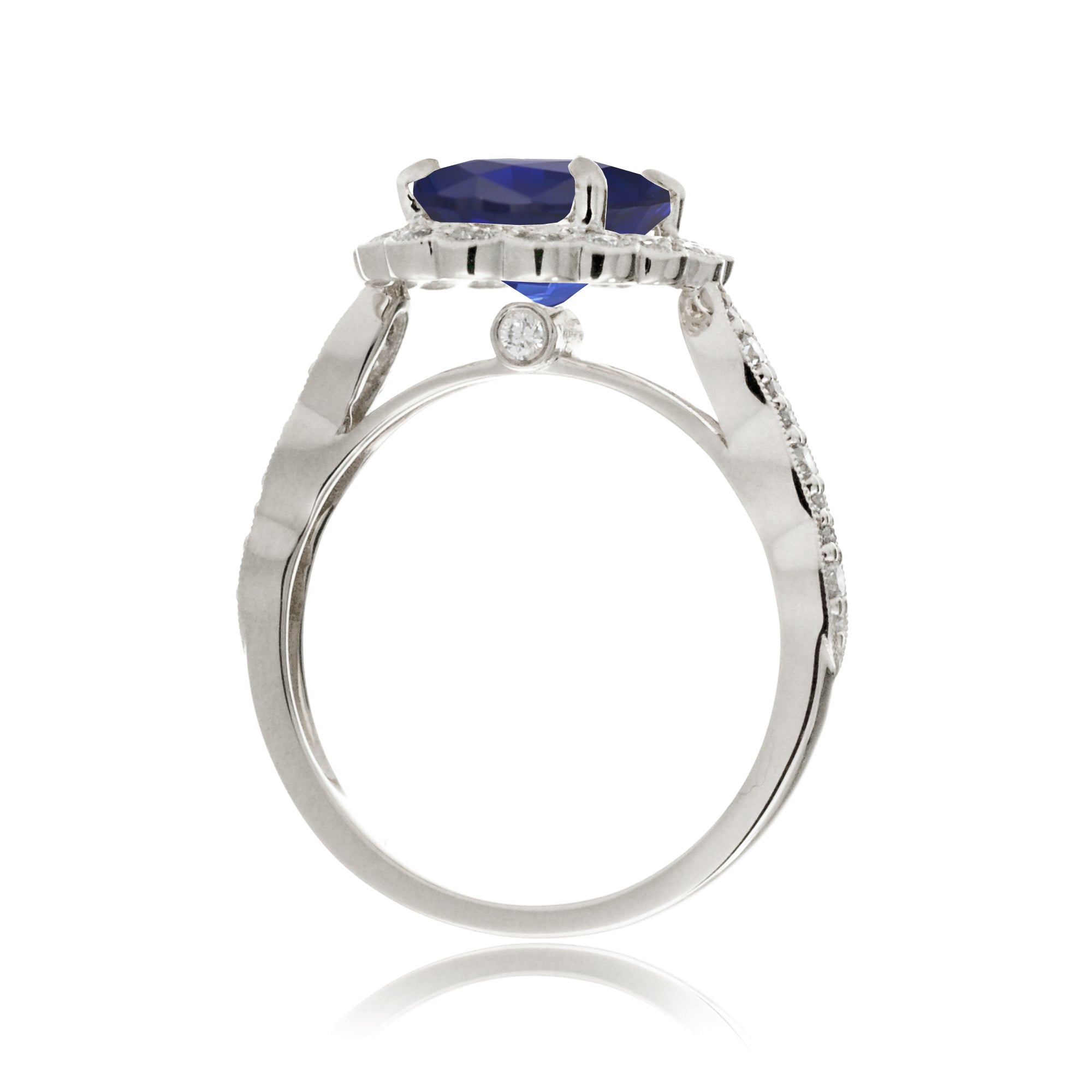 Blue oval sapphire ring with diamond halo in a vintage scallop design white gold
