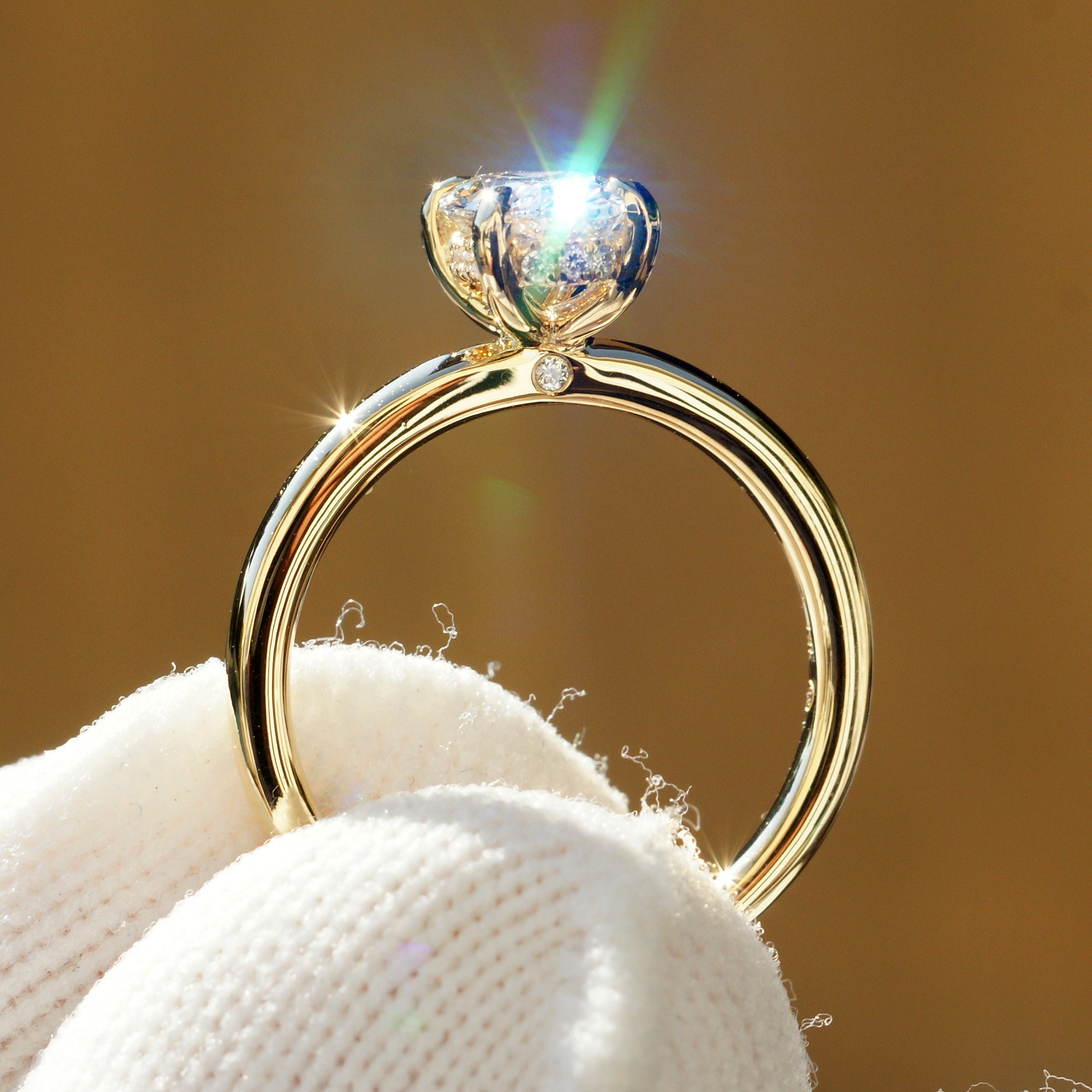 Side profile showing hidden diamond halo and detailed four-prong setting on yellow gold ring