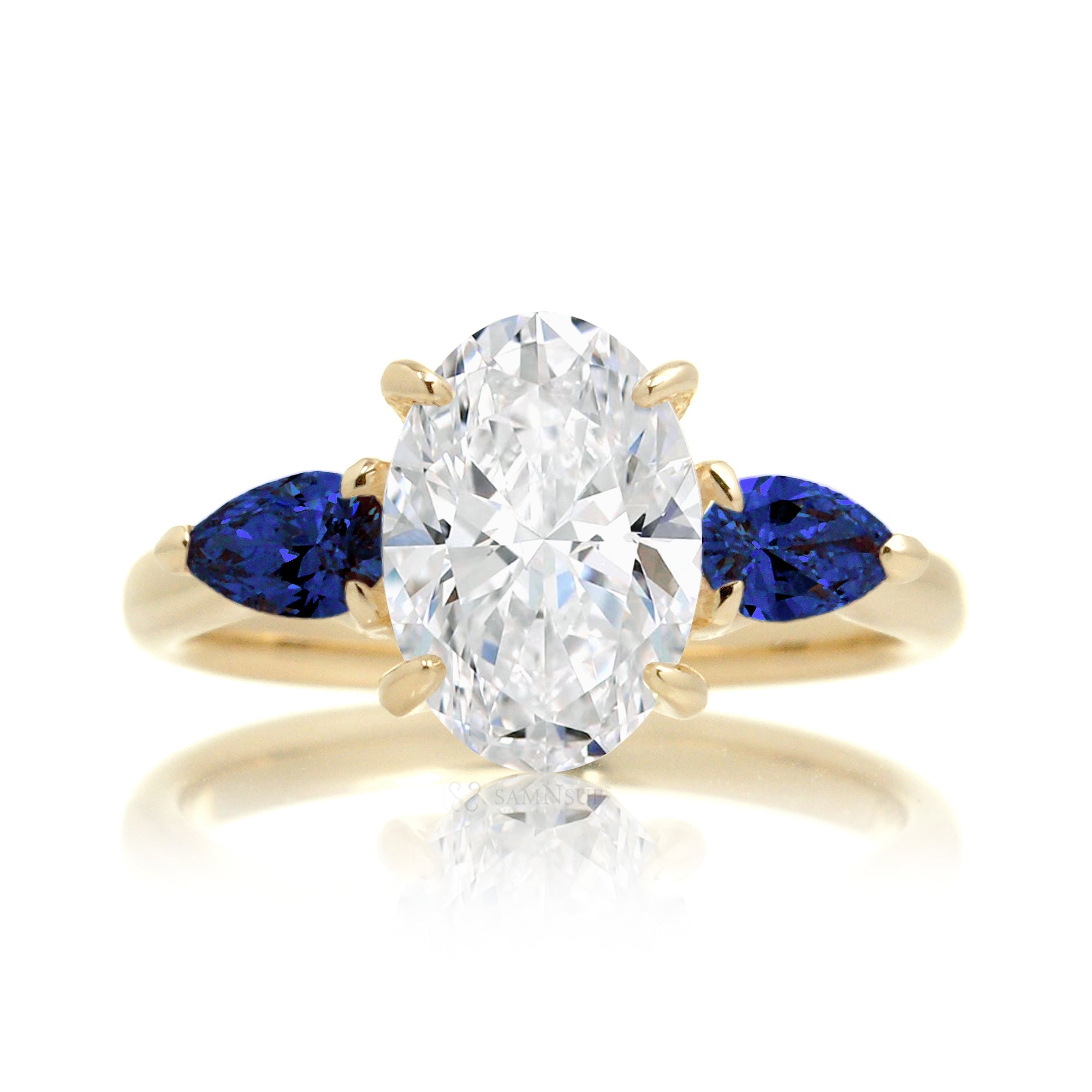 Three-stone pear sapphire and oval cut diamond engagement ring yellow gold
