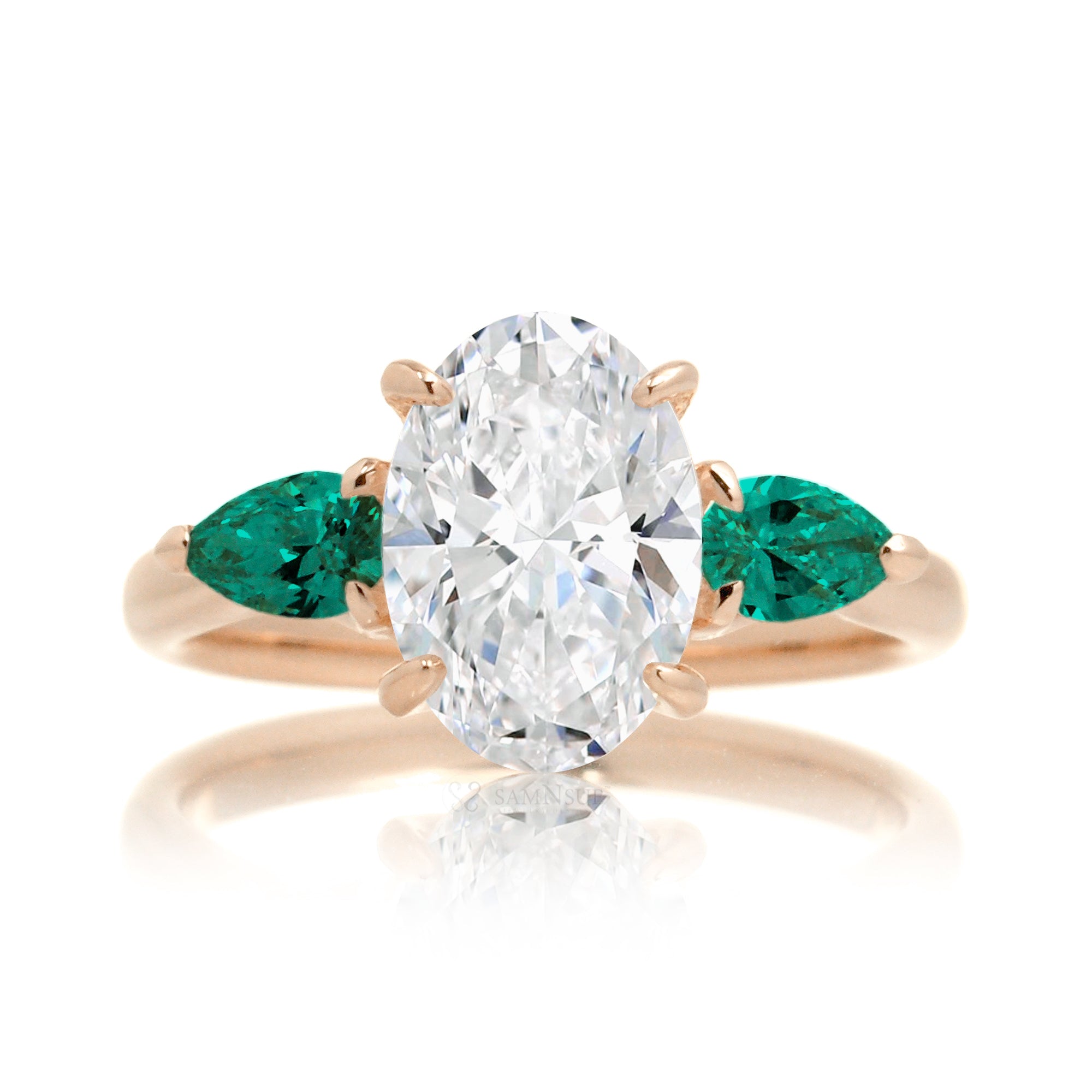 Three-stone pear emerald and oval cut diamond engagement ring rose gold