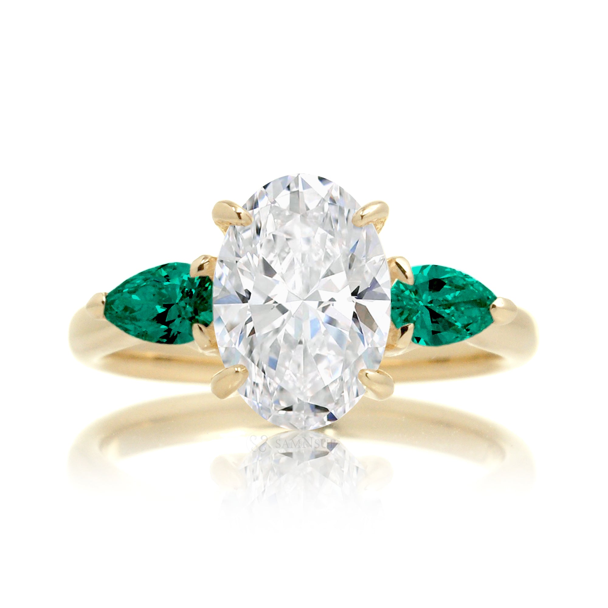 Three-stone pear emerald and oval cut diamond engagement ring yellow gold