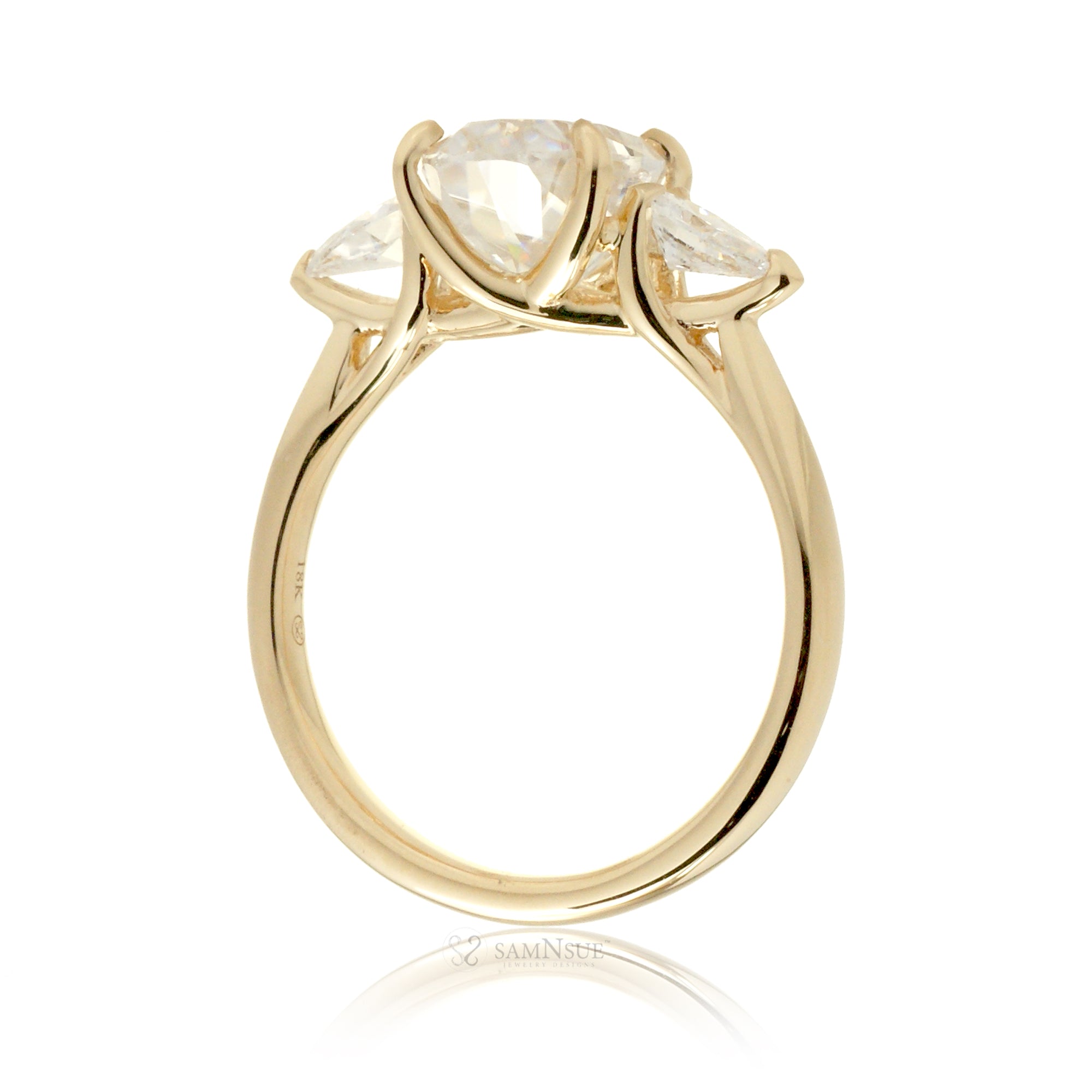 Side profile of oval cut moissanite three-stone ring in 18k yellow gold with pear-shaped accent stones