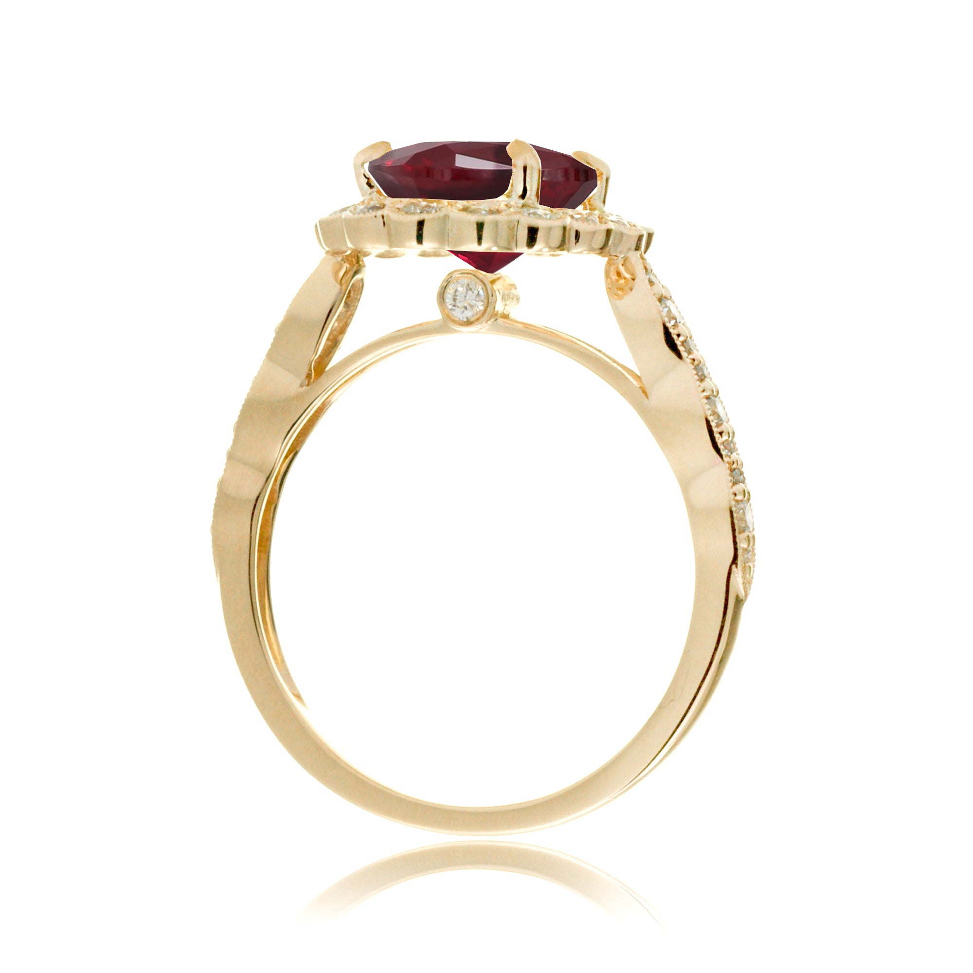 Oval cut ruby and diamond engagement ring with a vintage scallop band and halo yellow gold
