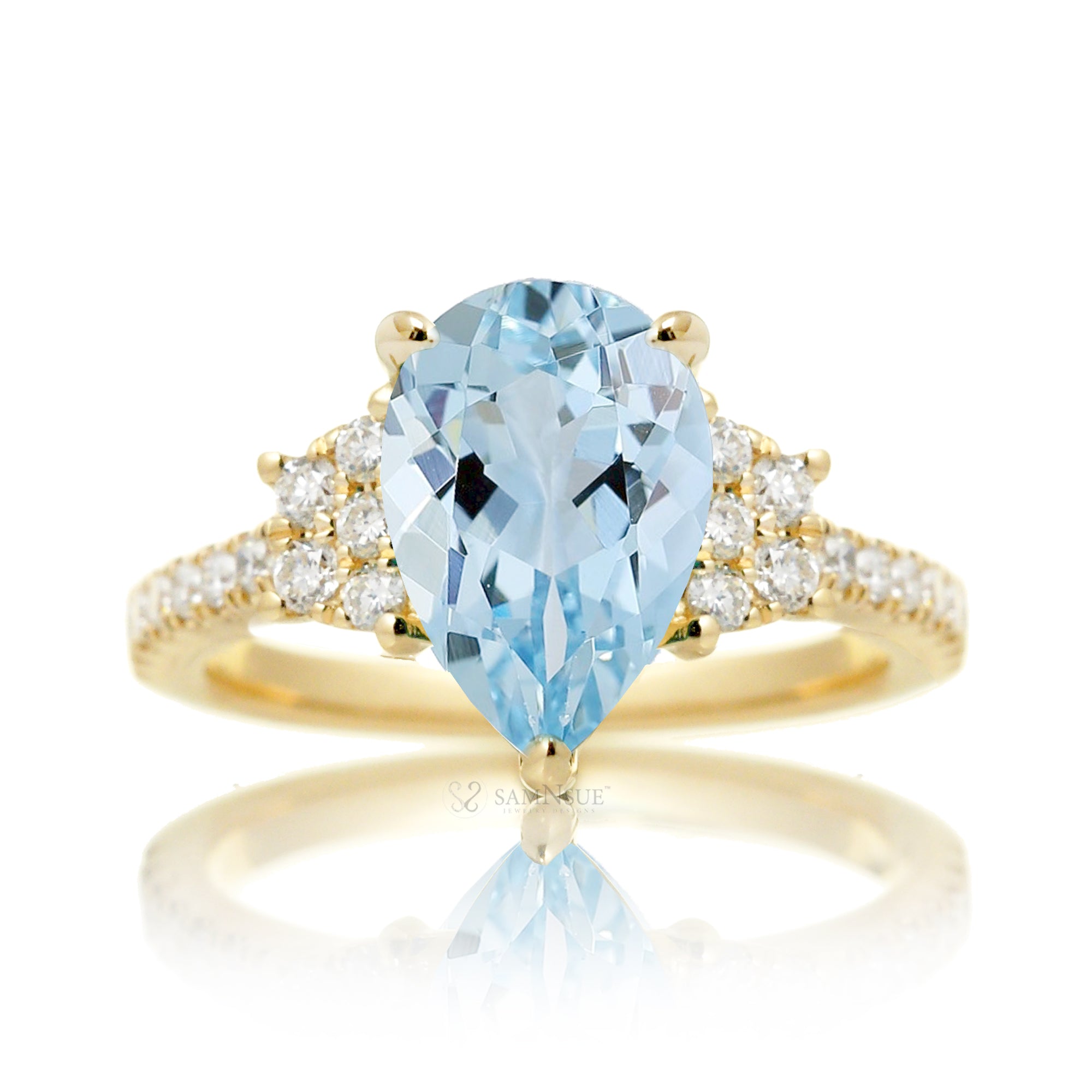 Pear aquamarine with diamond accent on the band and trapezoid shape side stones yellow gold