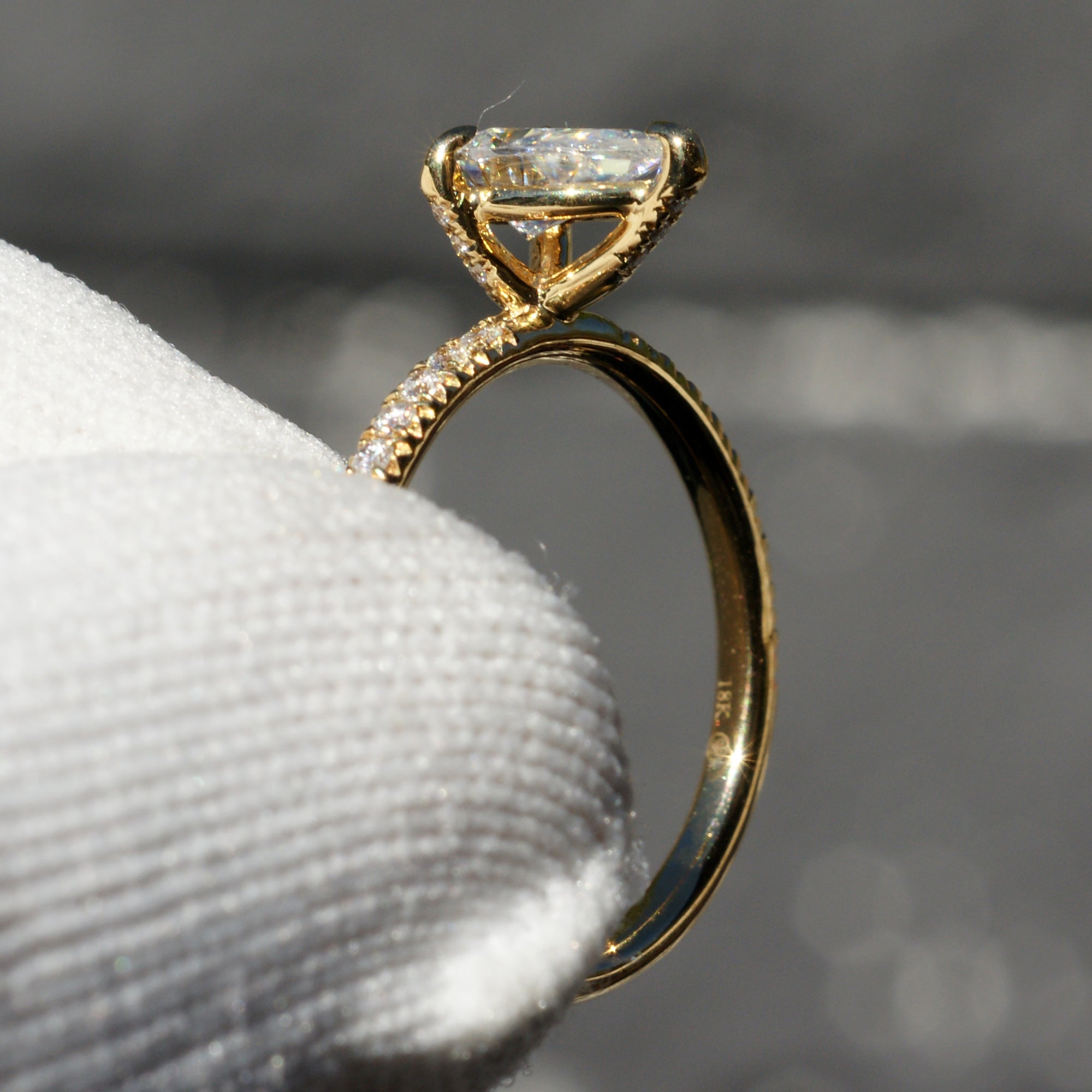 Pear moissanite engagement ring in yellow gold with diamond accent on prongs