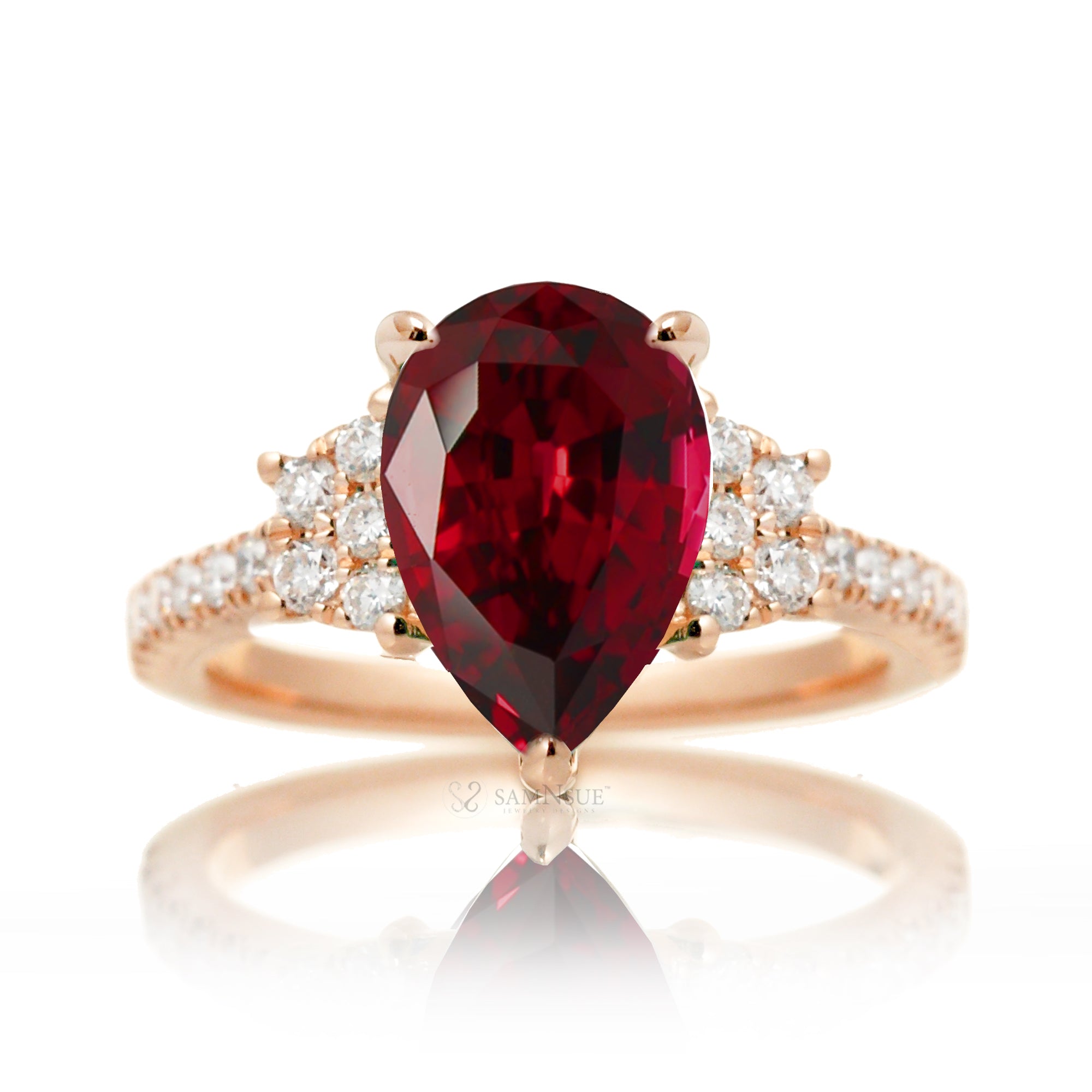 Pear cut ruby ring with trapezoid diamond side shape and band in rose gold