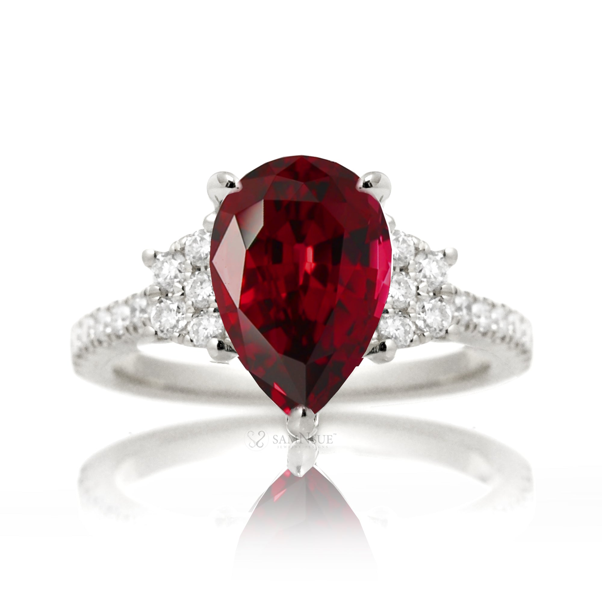 Pear cut ruby ring with trapezoid diamond side shape and band in white gold