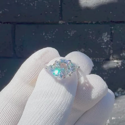 Oval moissanite three stone ring with trillion on each side in white gold