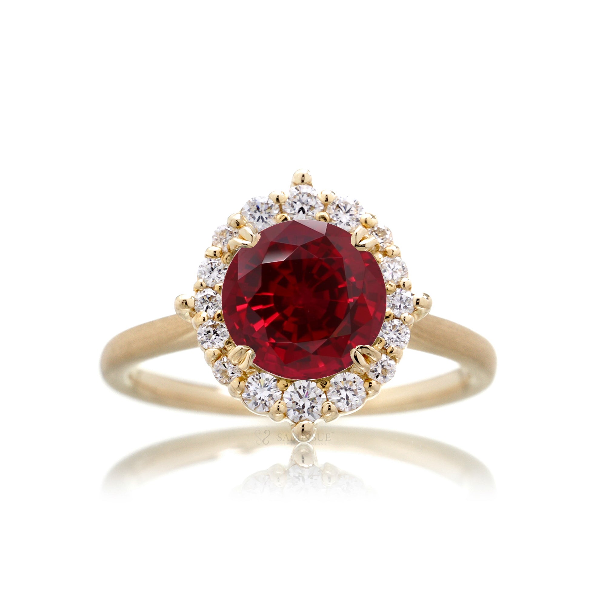 Round cut ruby diamond halo engagement ring with a solid yellow gold band