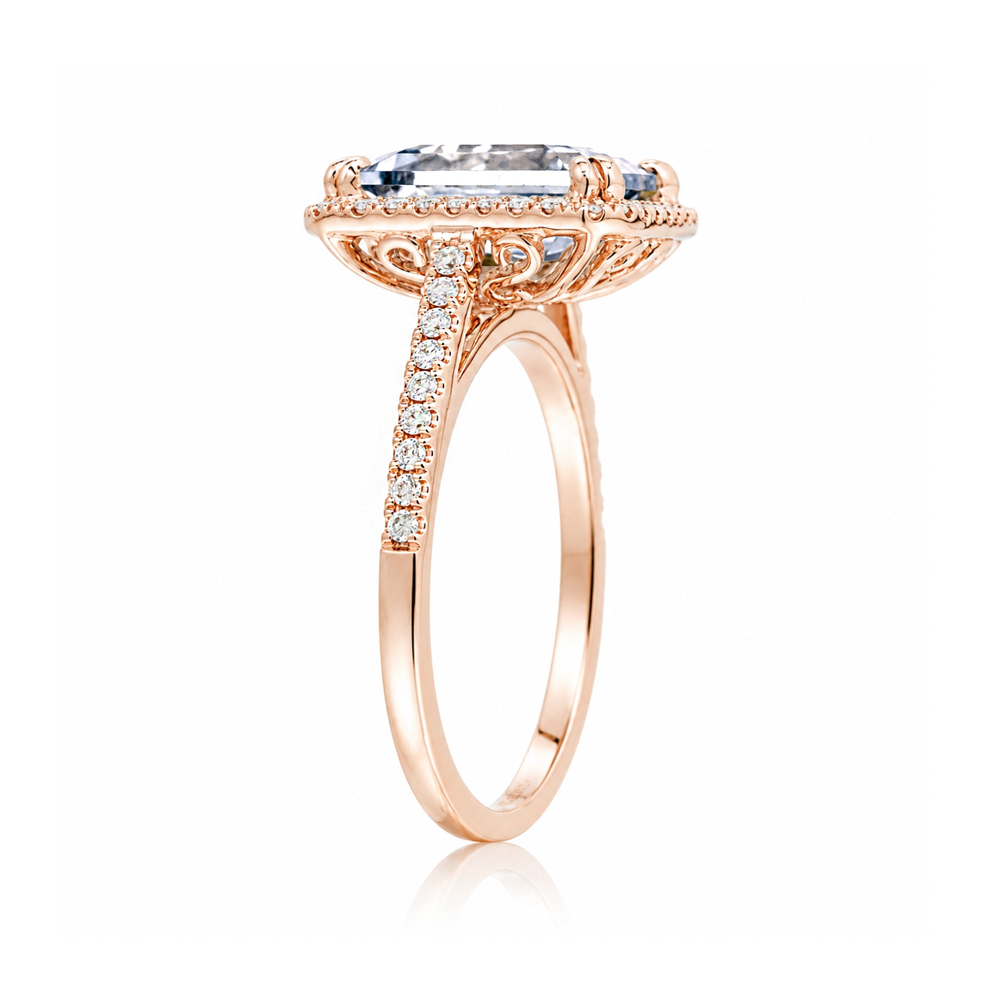 Emerald step cut diamond halo ring with a squarish band and cathedral setting rose gold