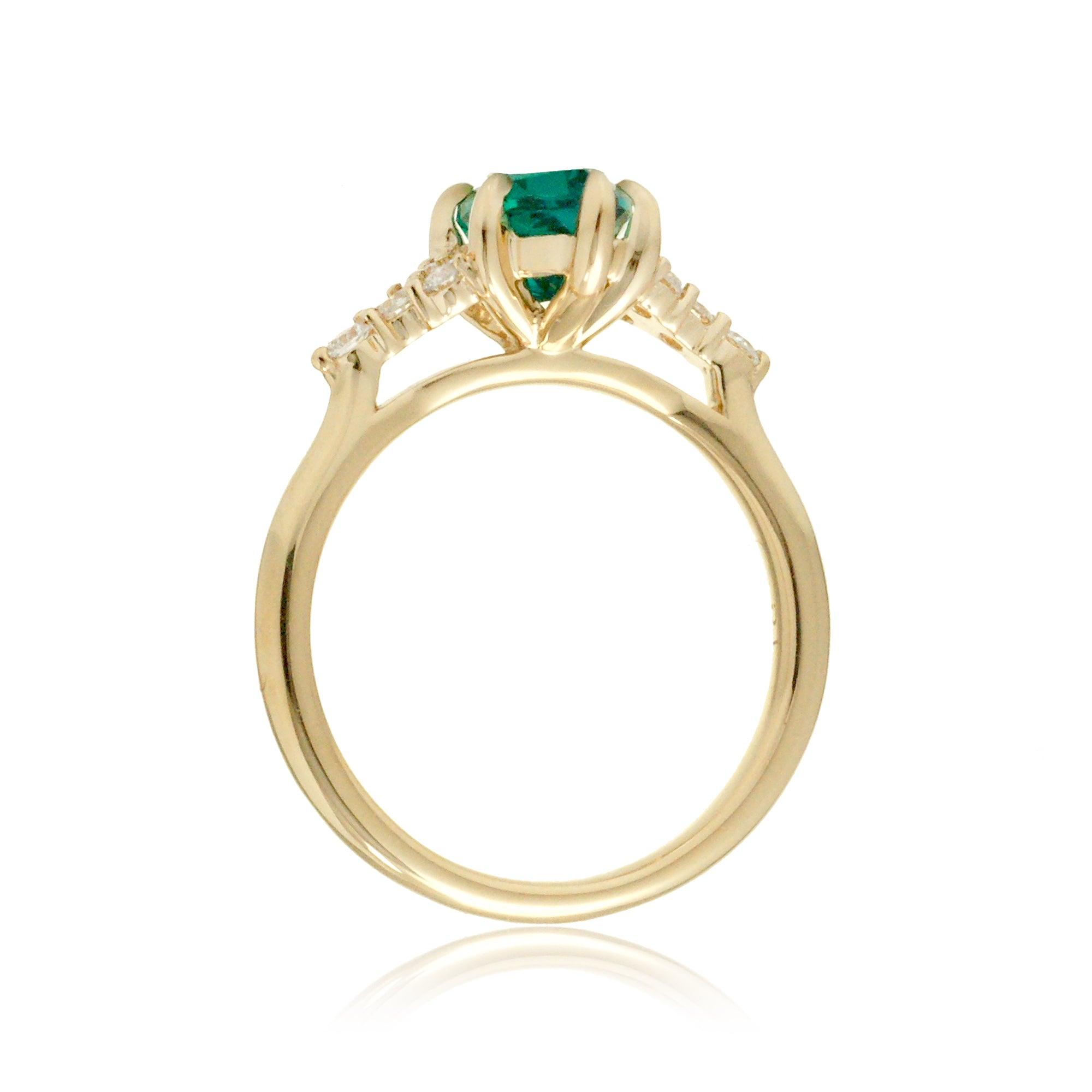 Gold ring with a green gemstone on a white background