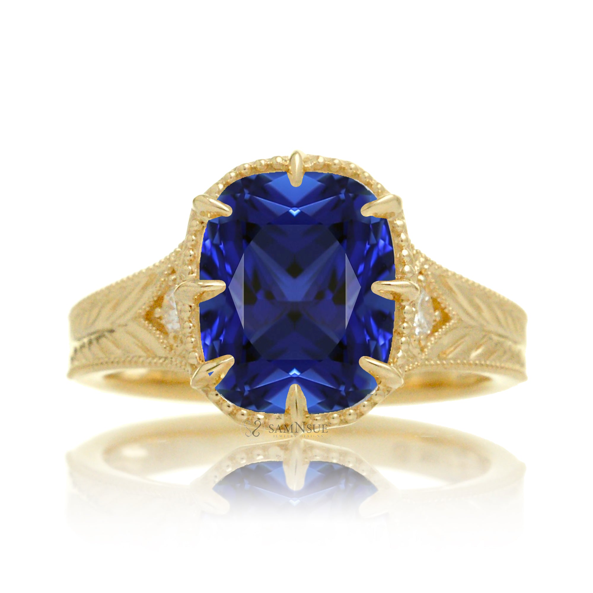 A cushion cut blue sapphire glimmers at the heart of this vintage-inspired engagement ring, set in polished yellow gold. The detailed band features hand-carved artistry, enhancing the antique character and timeless appeal.
