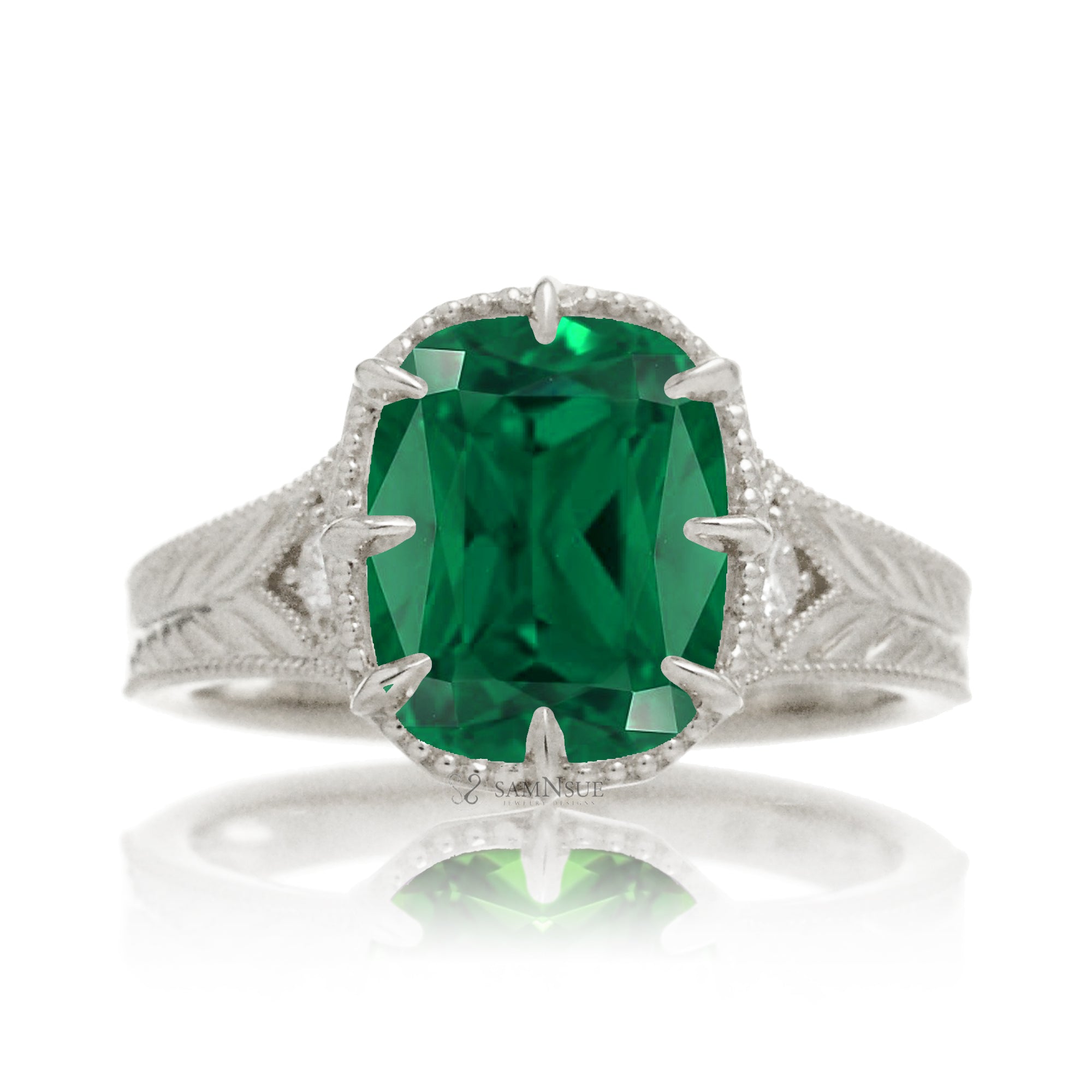 This heirloom-style ring showcases a cushion-shaped emerald. The white gold setting, paired with intricate engraving, creates a romantic design reminiscent of old-world glamour.