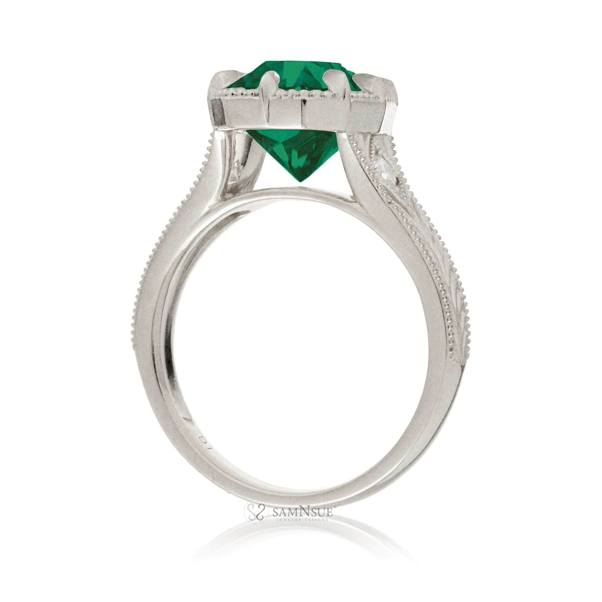 This heirloom-style ring showcases a cushion-shaped emerald. The white gold setting, paired with intricate engraving, creates a romantic design reminiscent of old-world glamour.