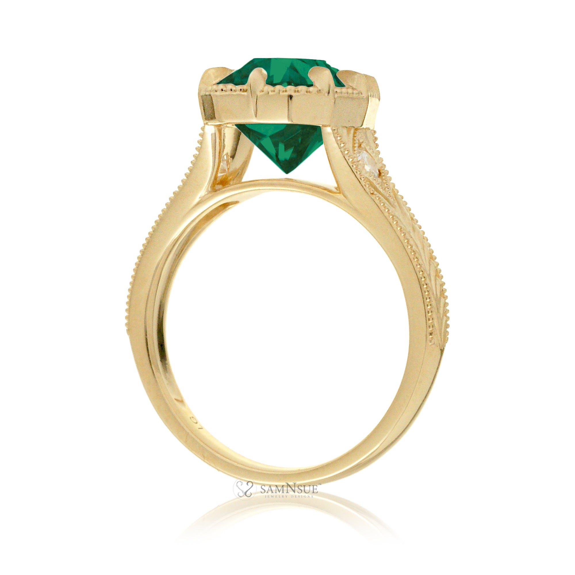 This heirloom-style ring showcases a cushion-shaped emerald. The warm yellow gold setting, paired with intricate engraving, creates a romantic design reminiscent of old-world glamour.