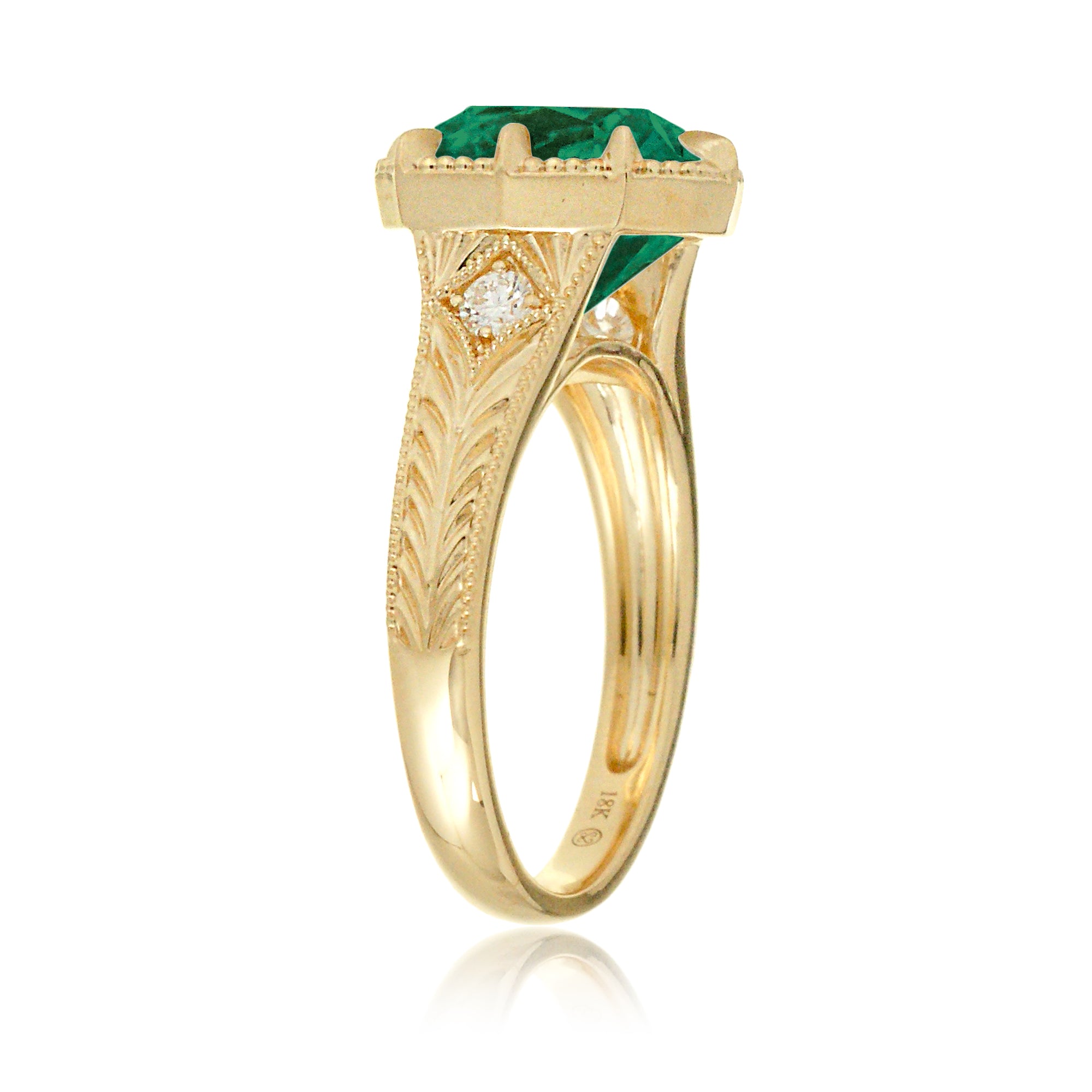 This heirloom-style ring showcases a cushion-shaped emerald. The warm yellow gold setting, paired with intricate engraving, creates a romantic design reminiscent of old-world glamour.