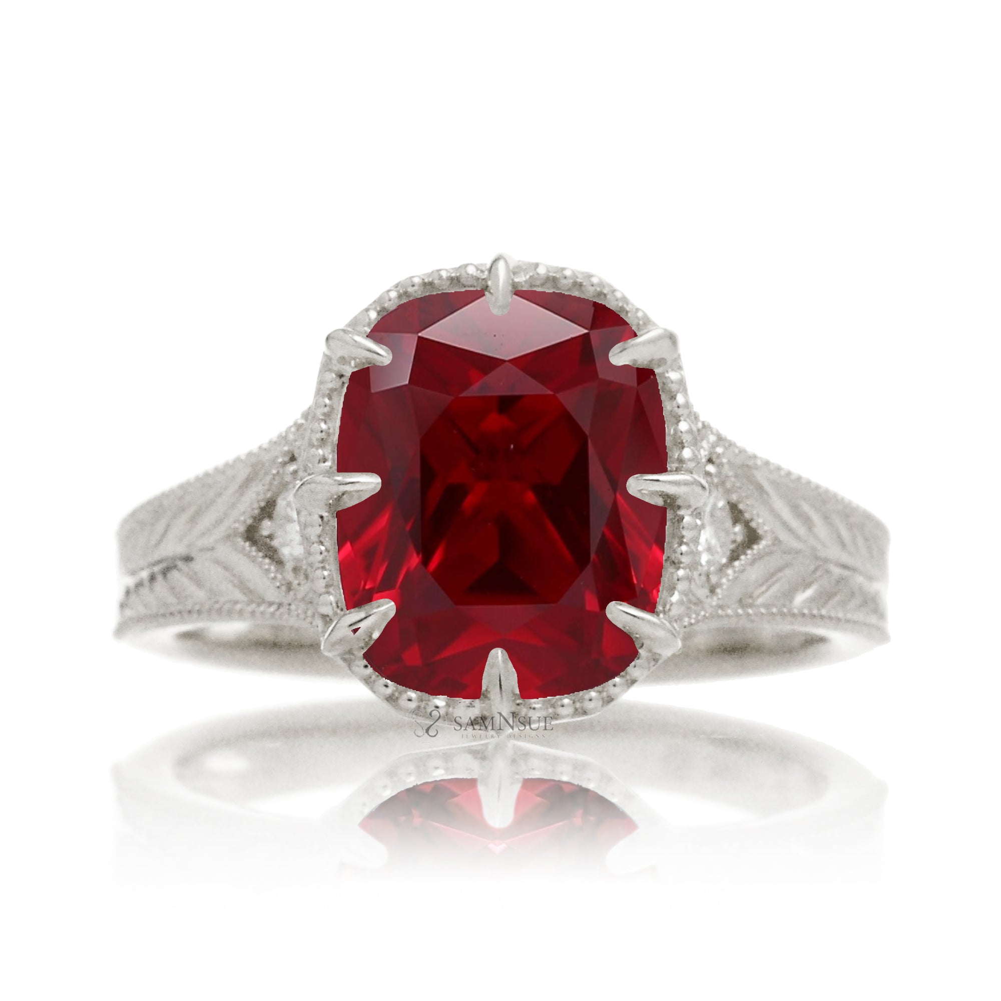 An elegant cushion cut ruby takes center stage in this vintage-style ring. The rich designed white gold band, adorned with delicate detailing, highlights the diamond’s fire and evokes a sense of classic, enduring romance.