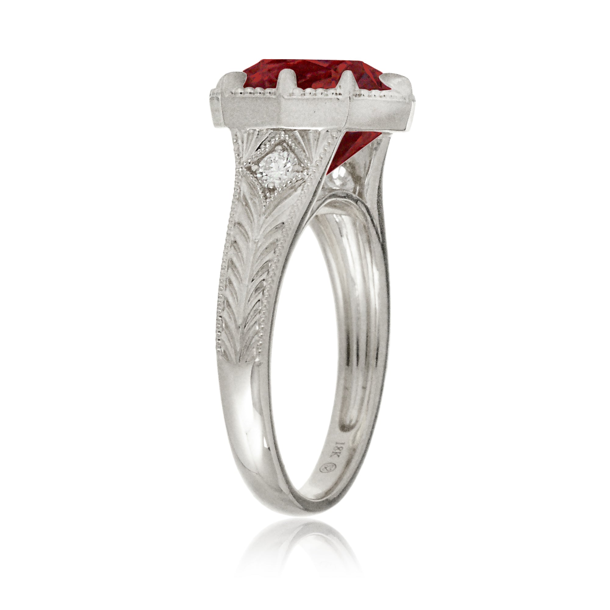 An elegant cushion cut ruby takes center stage in this vintage-style ring. The rich designed white gold band, adorned with delicate detailing, highlights the diamond’s fire and evokes a sense of classic, enduring romance.