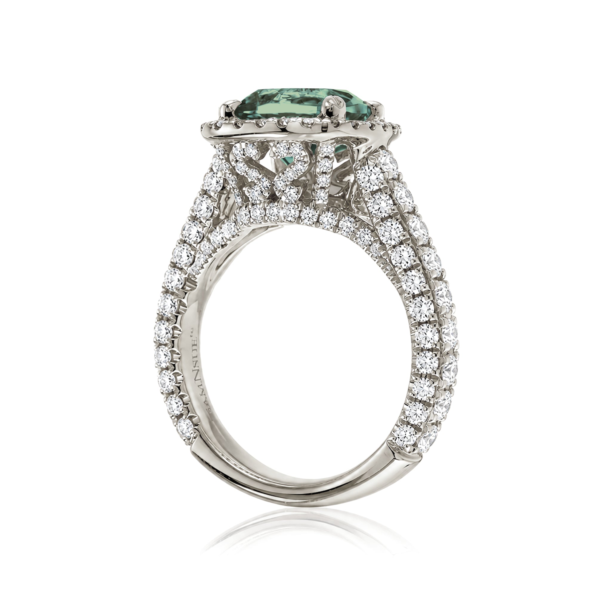 Cushion-cut green sapphire engagement ring in white gold with diamond halo and pavé diamond shoulders