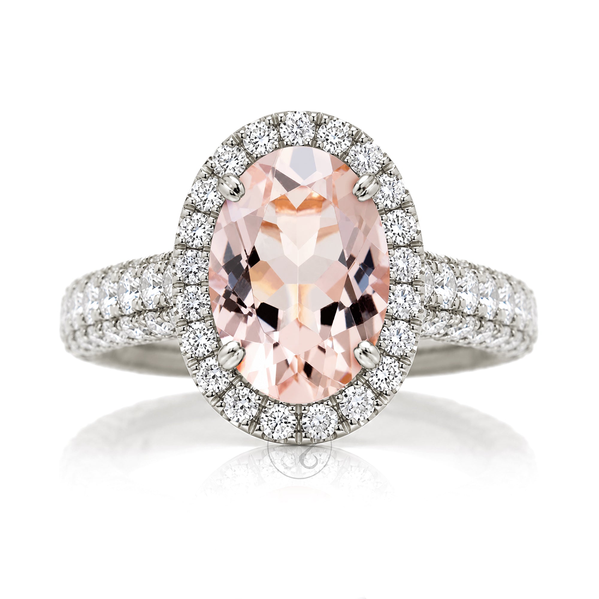 An oval-cut pink morganite halo ring in white gold, featuring a central peach-pink gemstone surrounded by a double halo of small clear stones and a diamond pavé band The Tamara