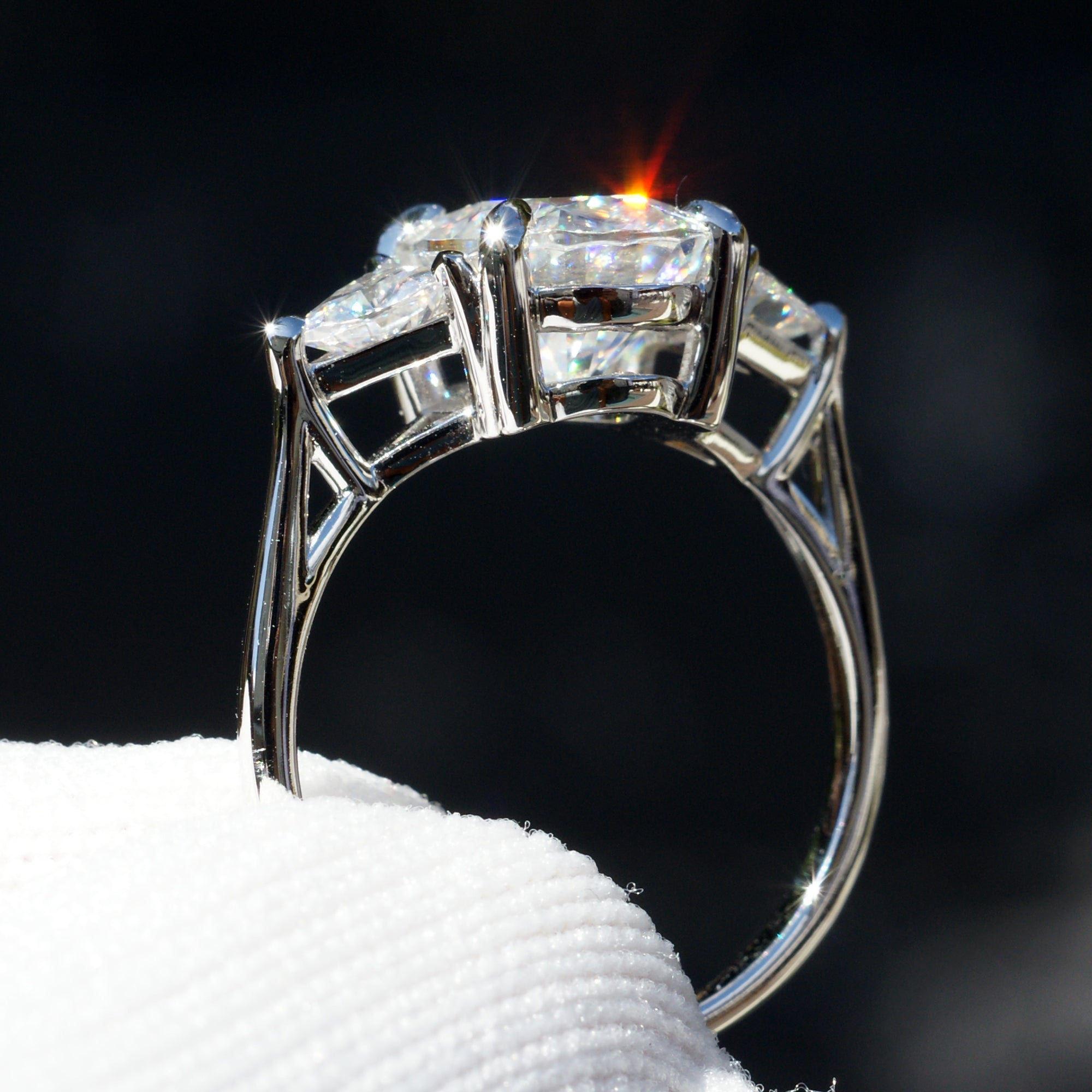Oval moissanite three stone ring with trillion on each side in white gold