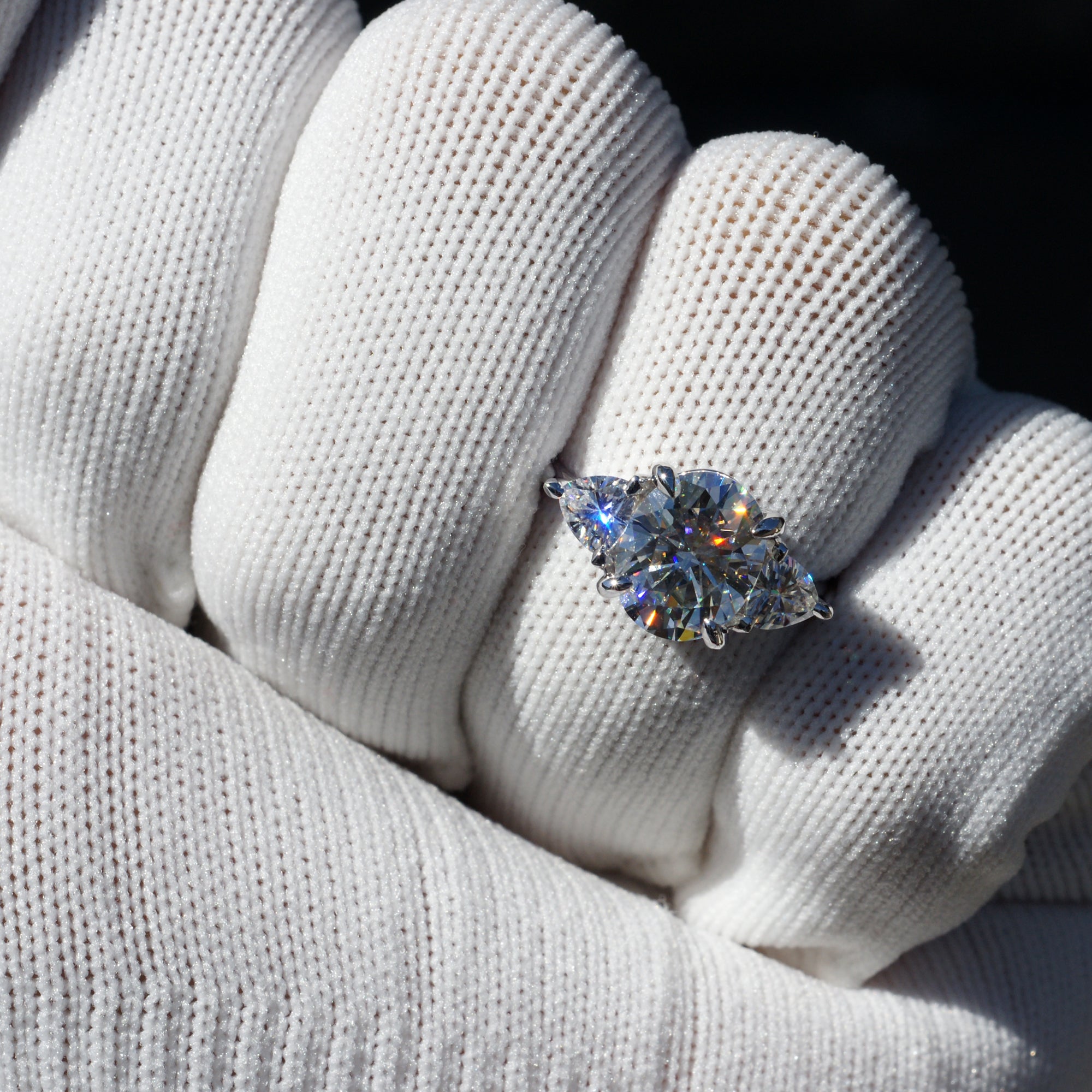 Oval moissanite three stone ring with trillion on each side in white gold