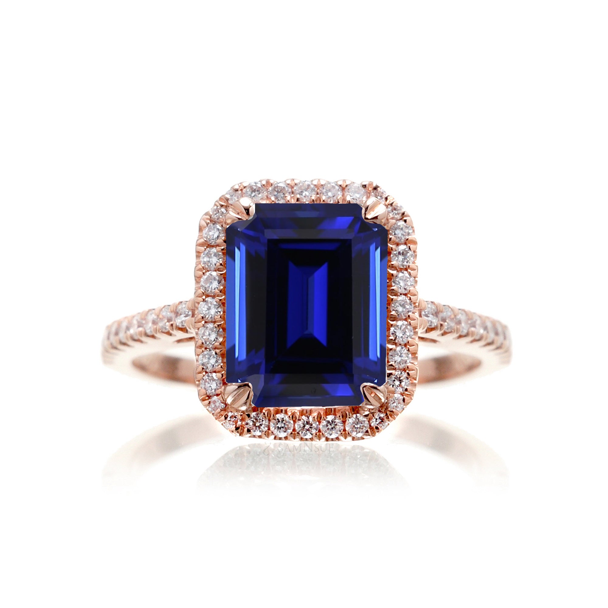 Emerald cut sapphire engagement ring with a diamond halo in rose gold