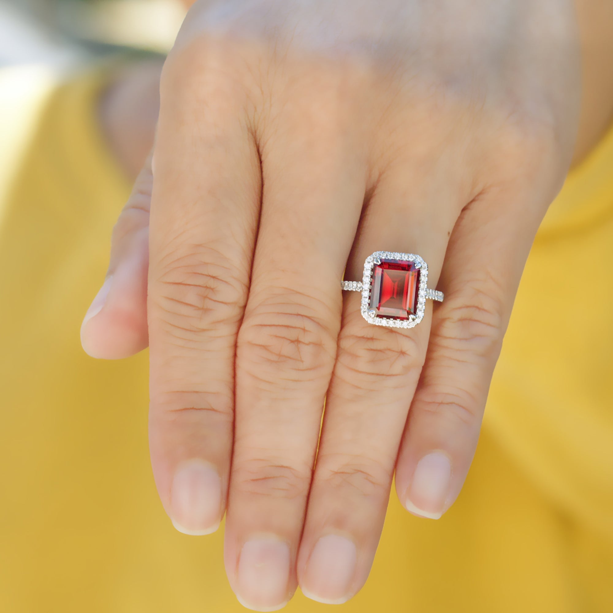 Emerald cut ruby engagement ring with diamond halo