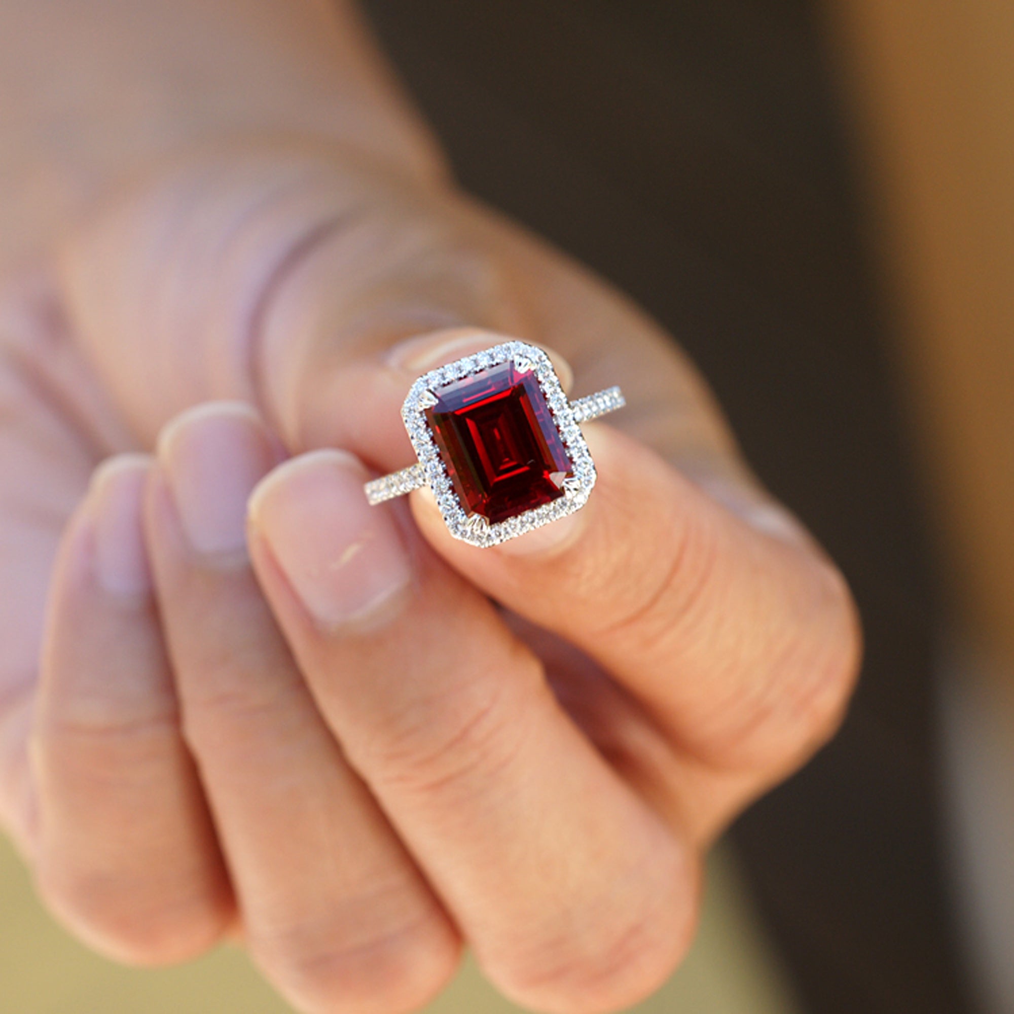 Emerald cut ruby engagement ring with diamond halo