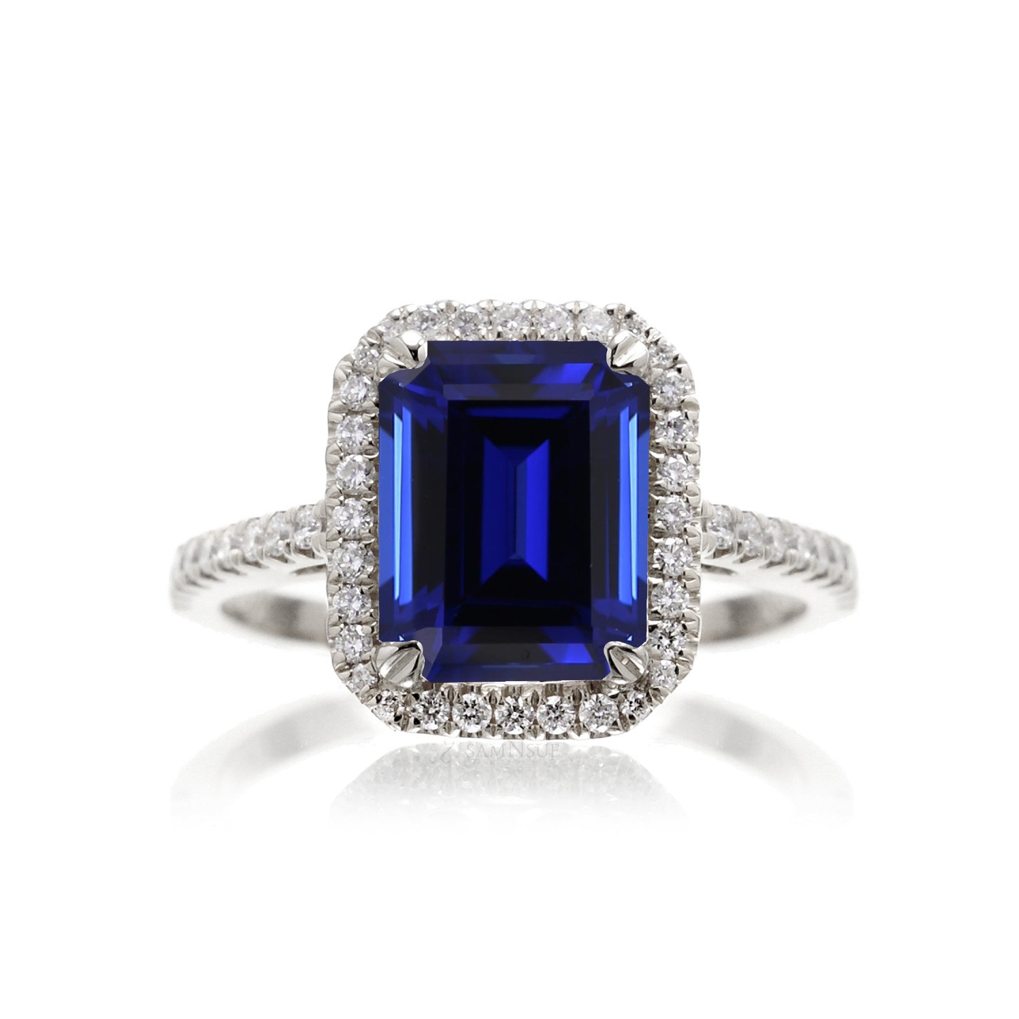 Emerald cut sapphire engagement ring with a diamond halo in white gold