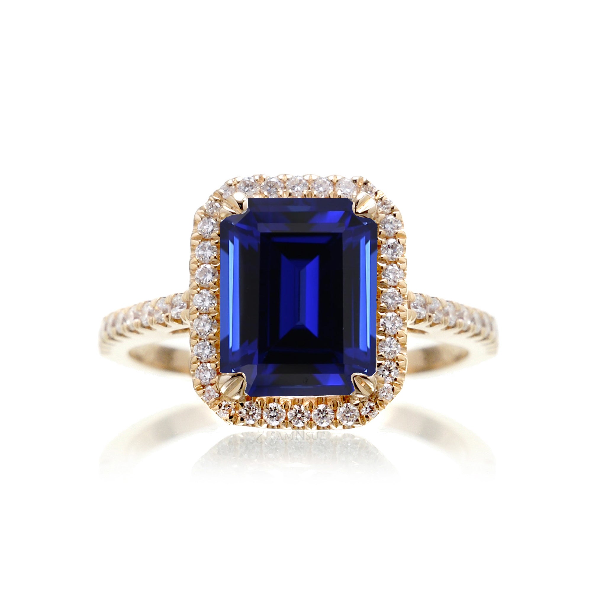 Emerald cut sapphire engagement ring with a diamond halo in yellow gold