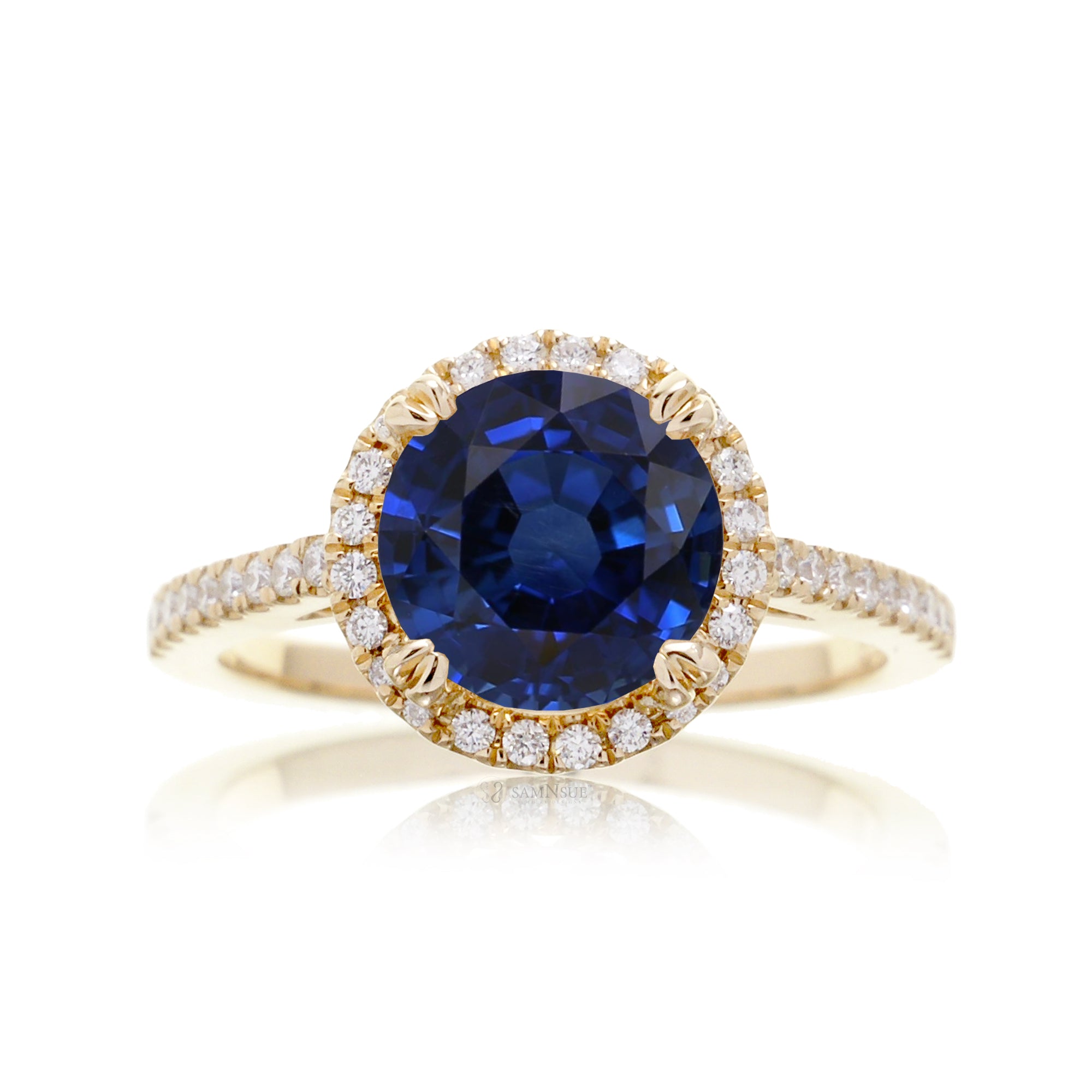 Round sapphire engagement ring with a diamond halo in yellow gold