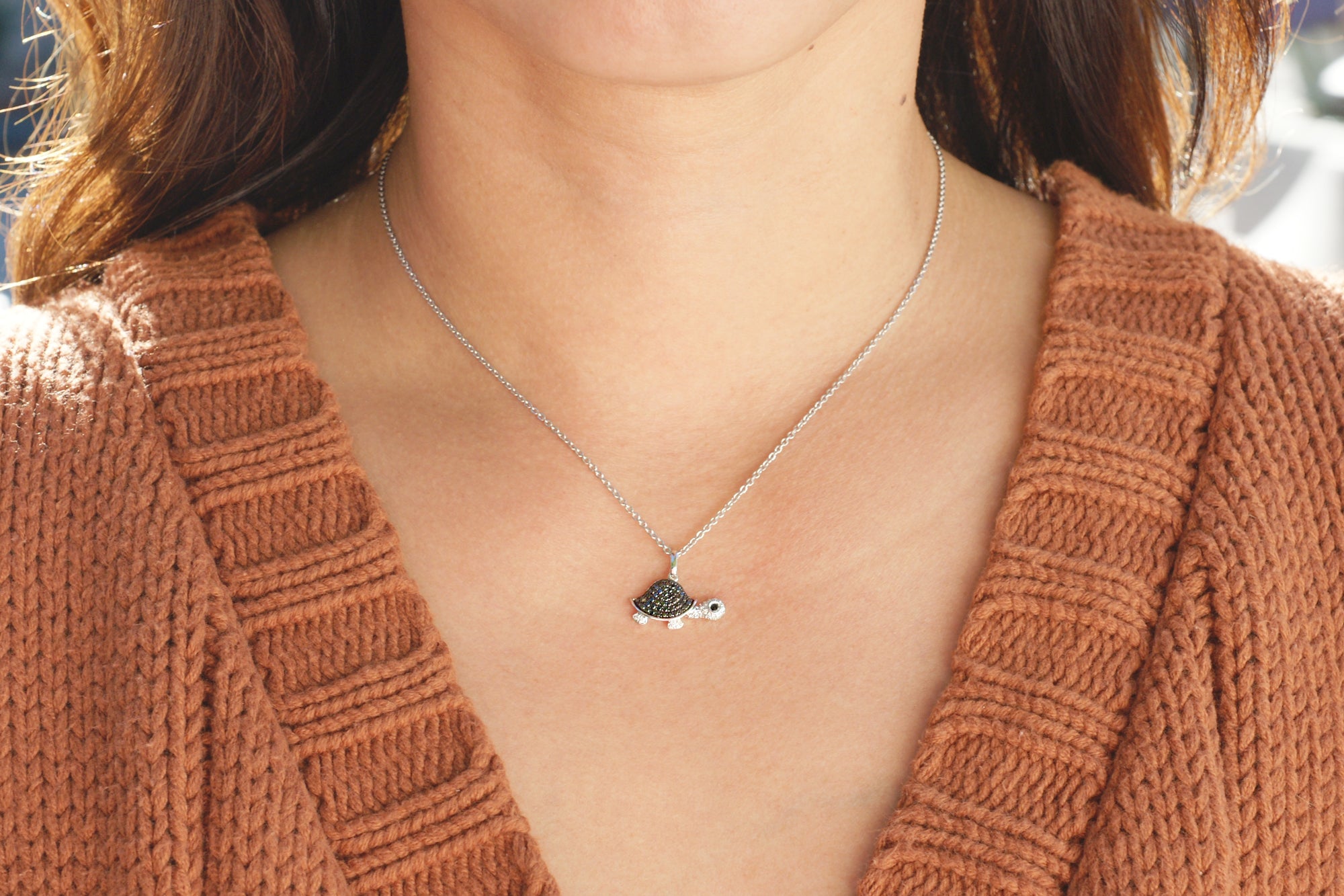 Black diamond turtle necklace on a model