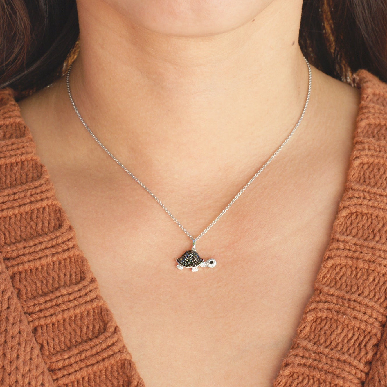 Black diamond turtle necklace on a model