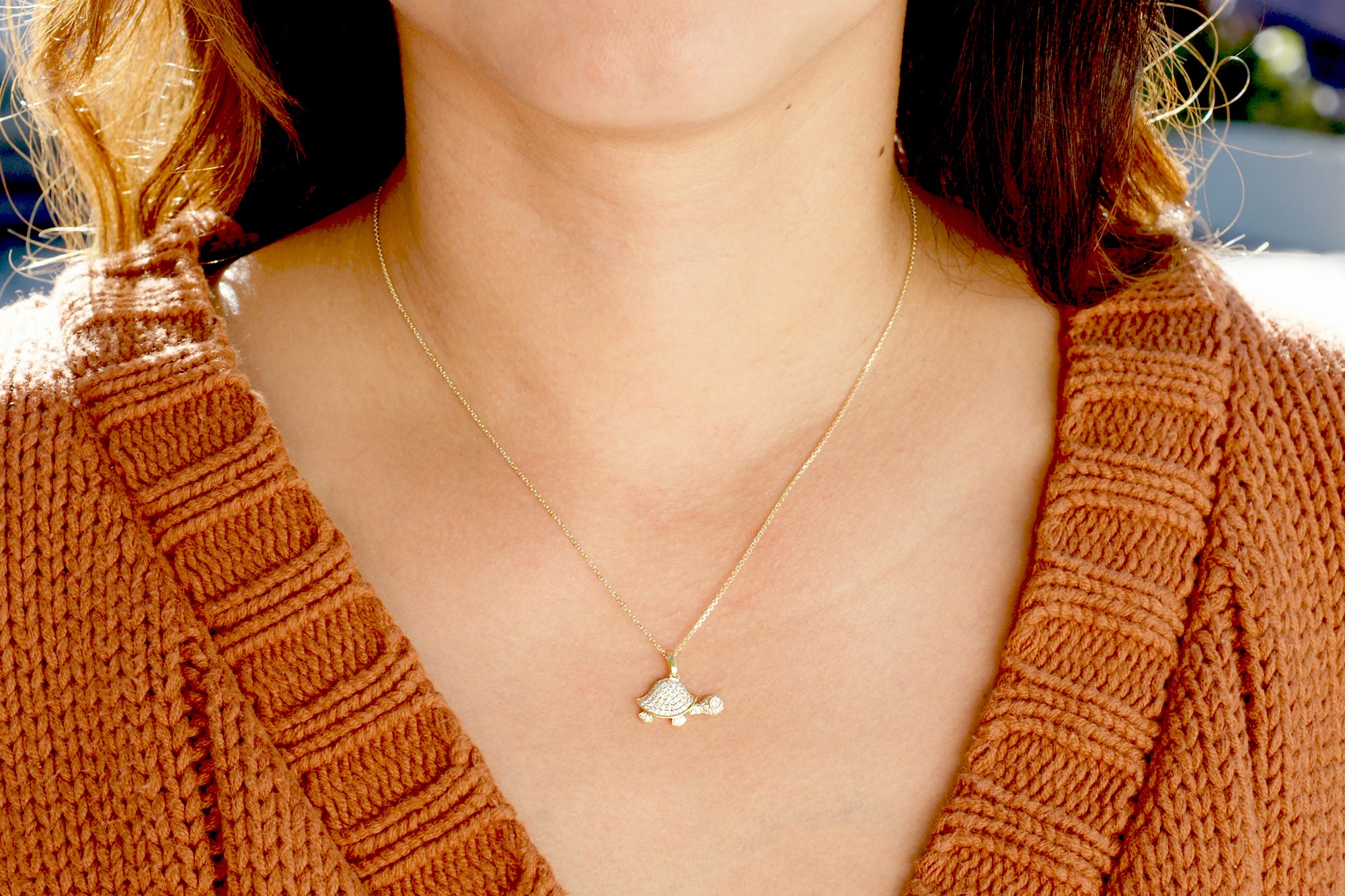 All white diamond turtle necklace on a model