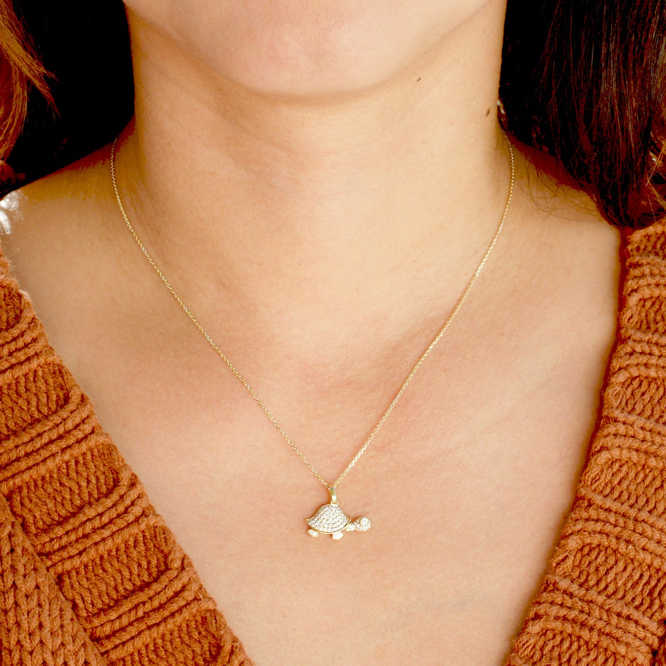 All white diamond turtle necklace on a model